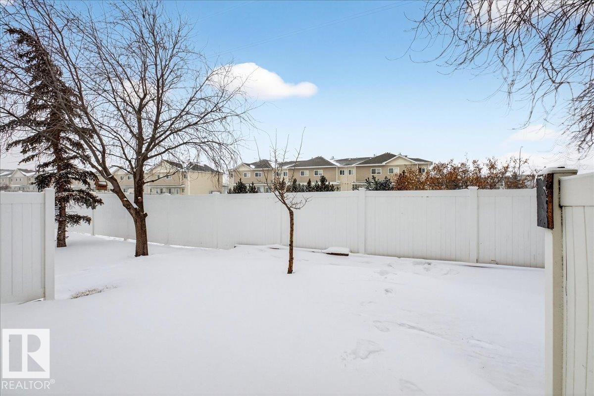 Snowy yard featuring a residential view - 47 230 Edwards Drive, Edmonton, AB - Outdoor