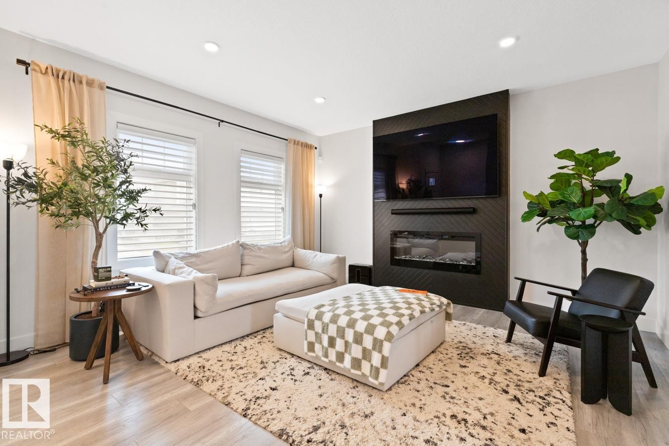 Living area featuring a textured accent wall with an integrated electric fireplace - 6023 180 Avenue, Edmonton, AB - Indoor Photo Showing Living Room With Fireplace