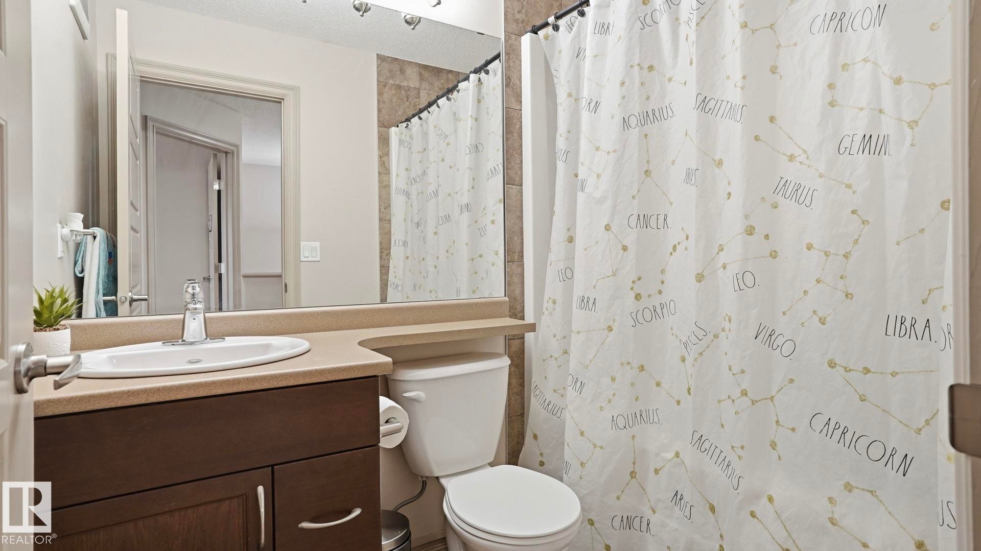 Bathroom vanity featuring a single basin sink and a wood-finish cabinet - 8210 180 Avenue Nw, Edmonton, AB - Indoor Photo Showing Bathroom