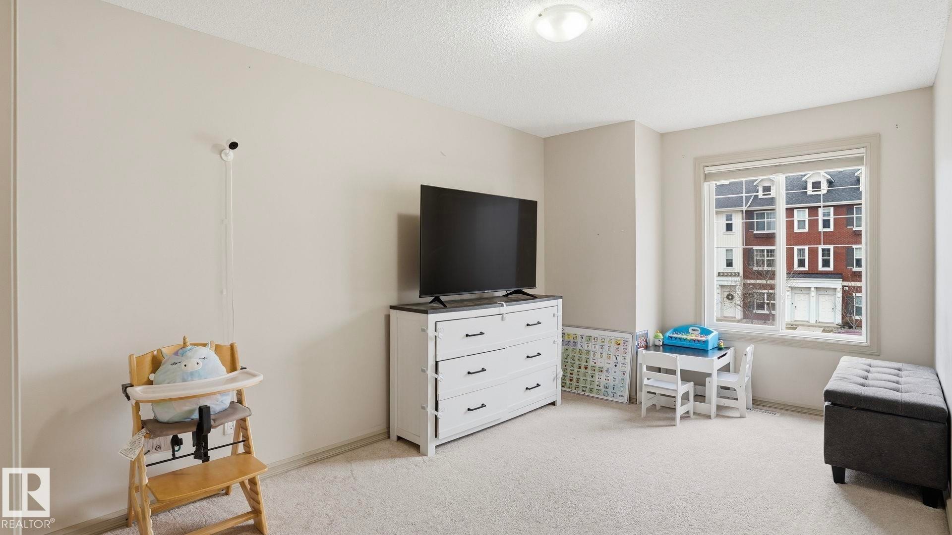 Carpeted room with neutral wall tones and a window featuring white trim - 8210 180 Avenue Nw, Edmonton, AB - Indoor