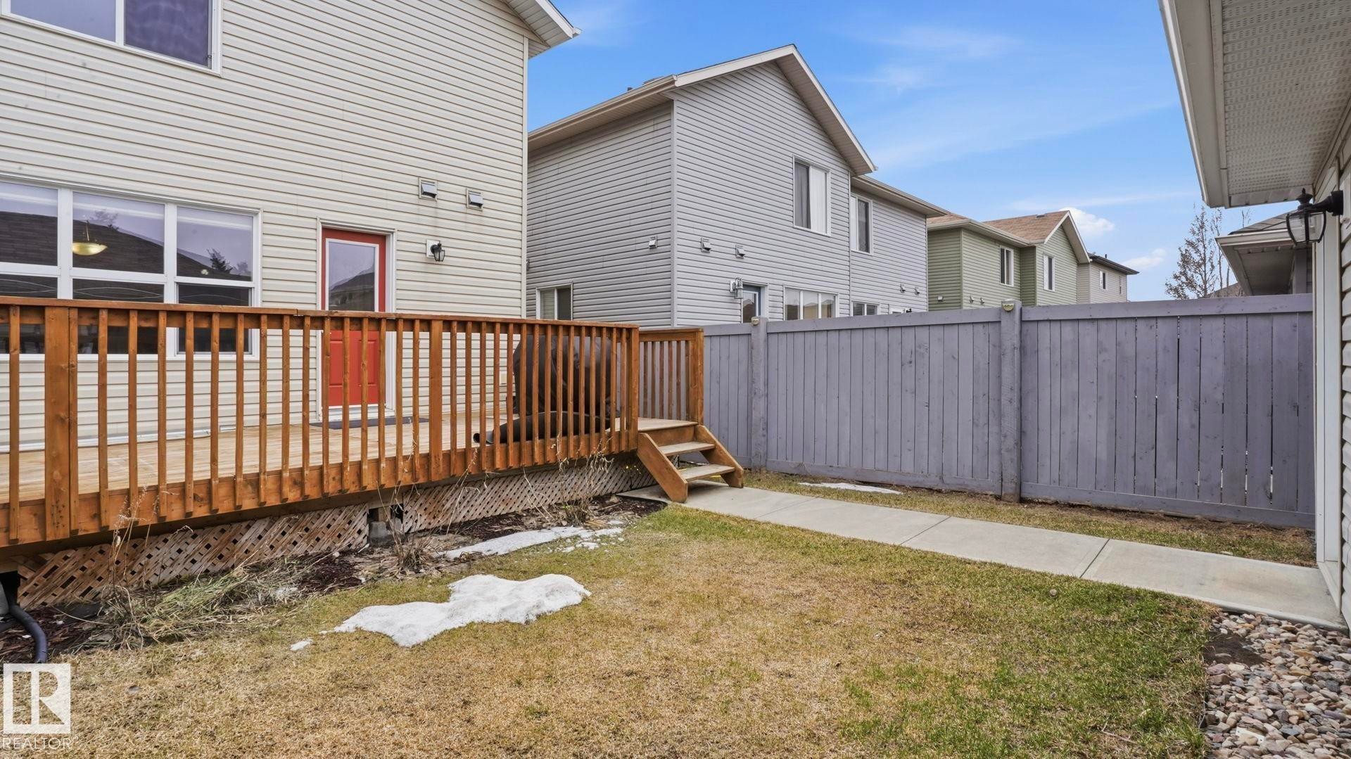 Expansive wooden deck with railing and stairs, providing direct access to the outdoor area - 8210 180 Avenue Nw, Edmonton, AB - Outdoor With Exterior