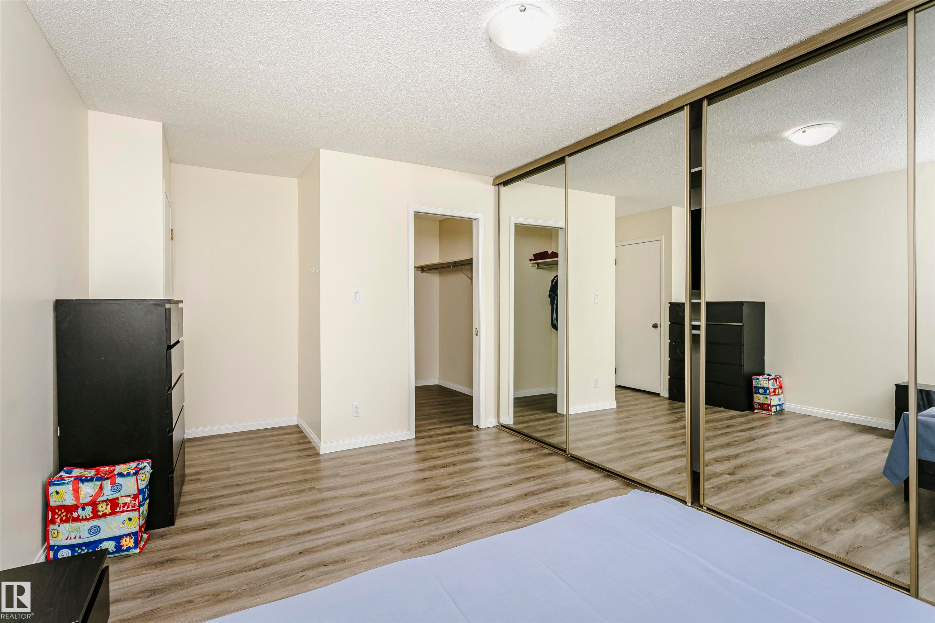 Room featuring wood-finish flooring, light-toned wall paint, and overhead flush-mount lighting - #303 10026 112 Street Nw, Edmonton, AB - Indoor