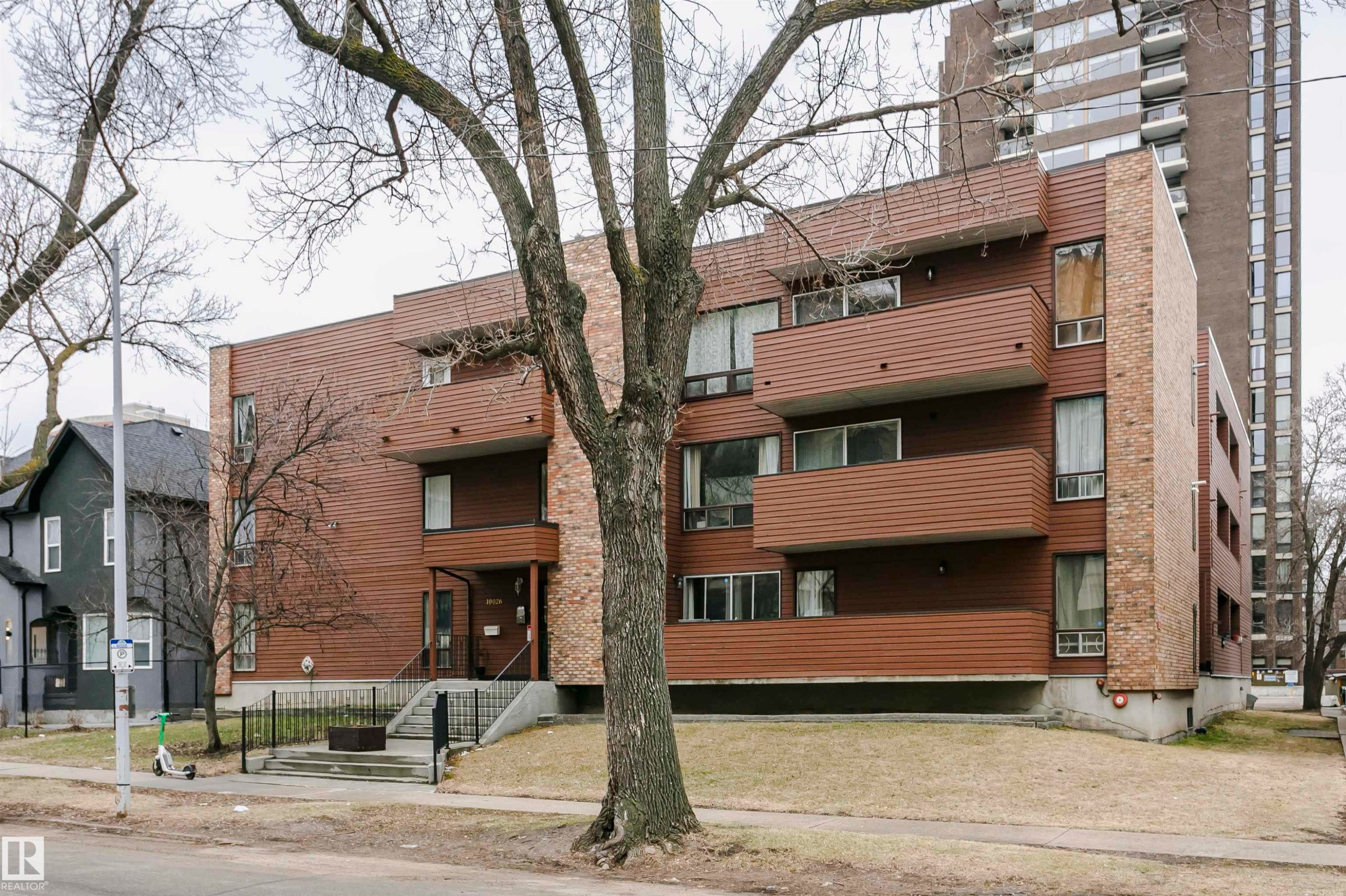 Multi-story building featuring horizontal brown siding and vertical brick accents - #303 10026 112 Street Nw, Edmonton, AB - Outdoor