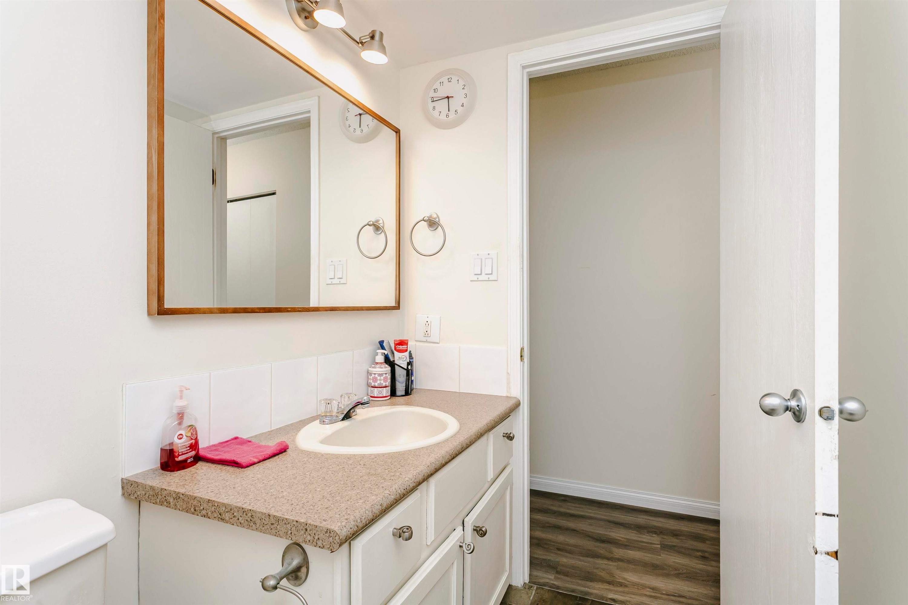 Bathroom vanity with a composite countertop, an undermount sink, and a framed mirror - #303 10026 112 Street Nw, Edmonton, AB - Indoor Photo Showing Bathroom