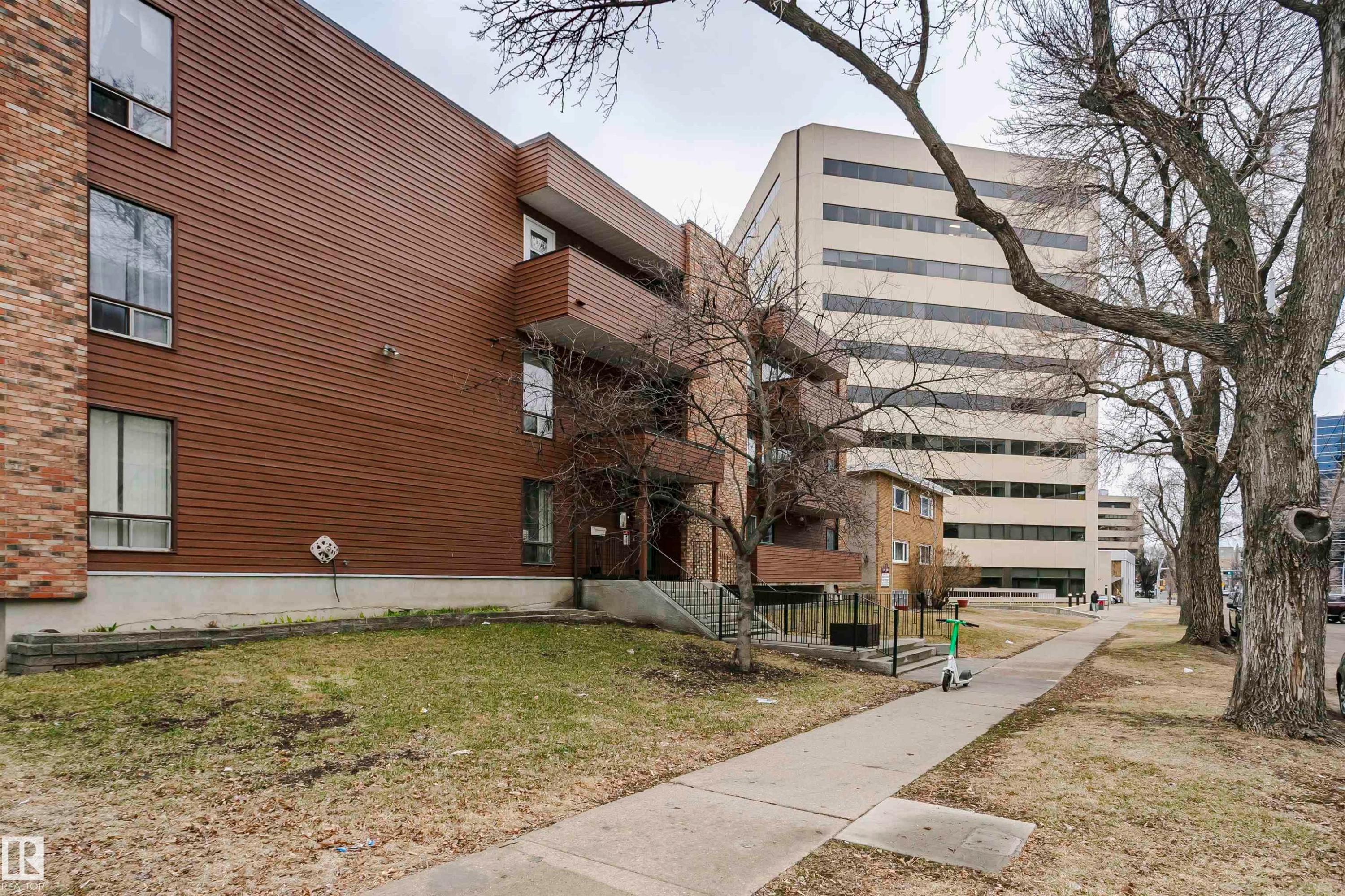 Multi-story residential building featuring horizontal brown siding and brick accents - #303 10026 112 Street Nw, Edmonton, AB - Outdoor