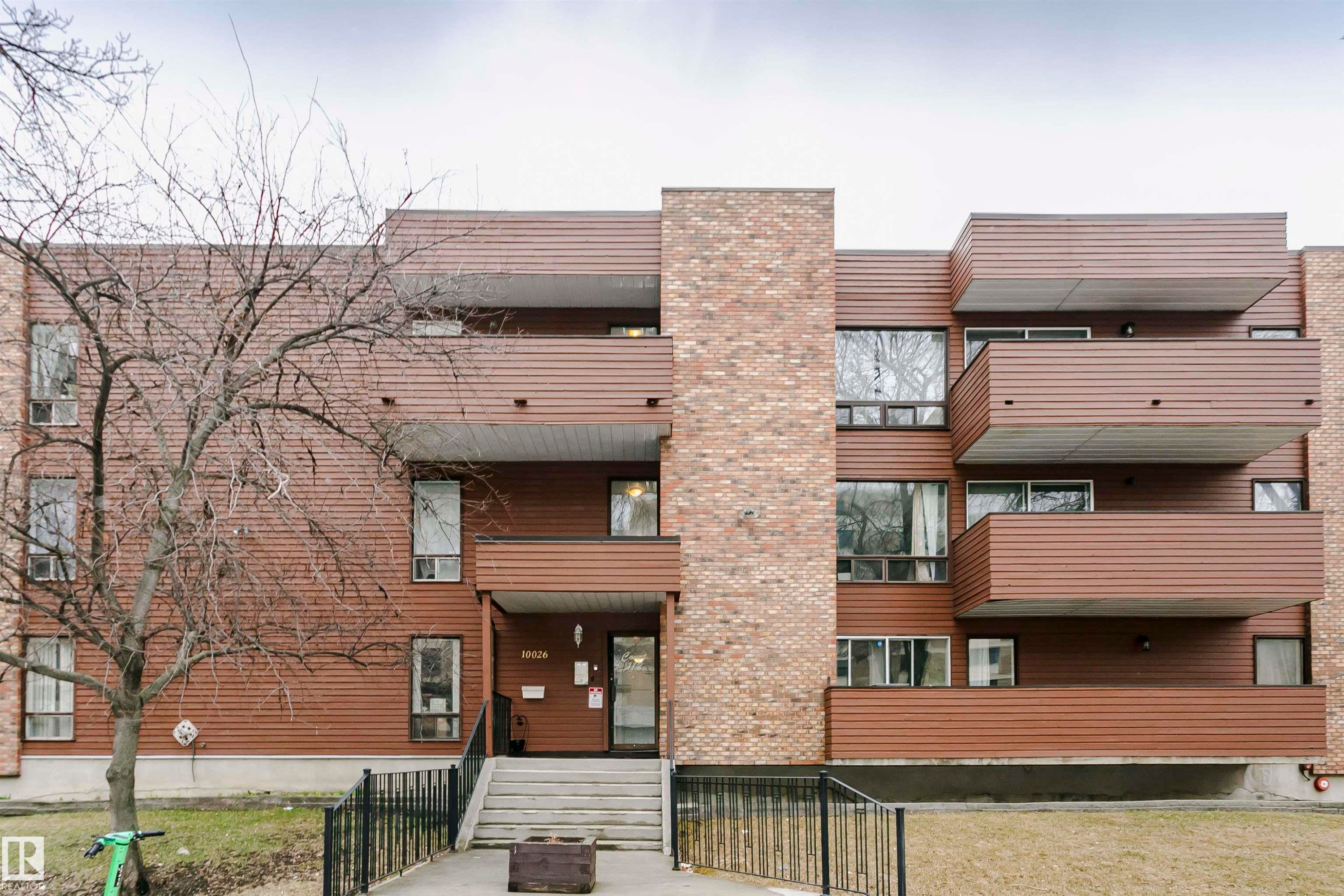Multi-level building exterior featuring brick and wood-finish siding - #303 10026 112 Street Nw, Edmonton, AB - Outdoor With Exterior