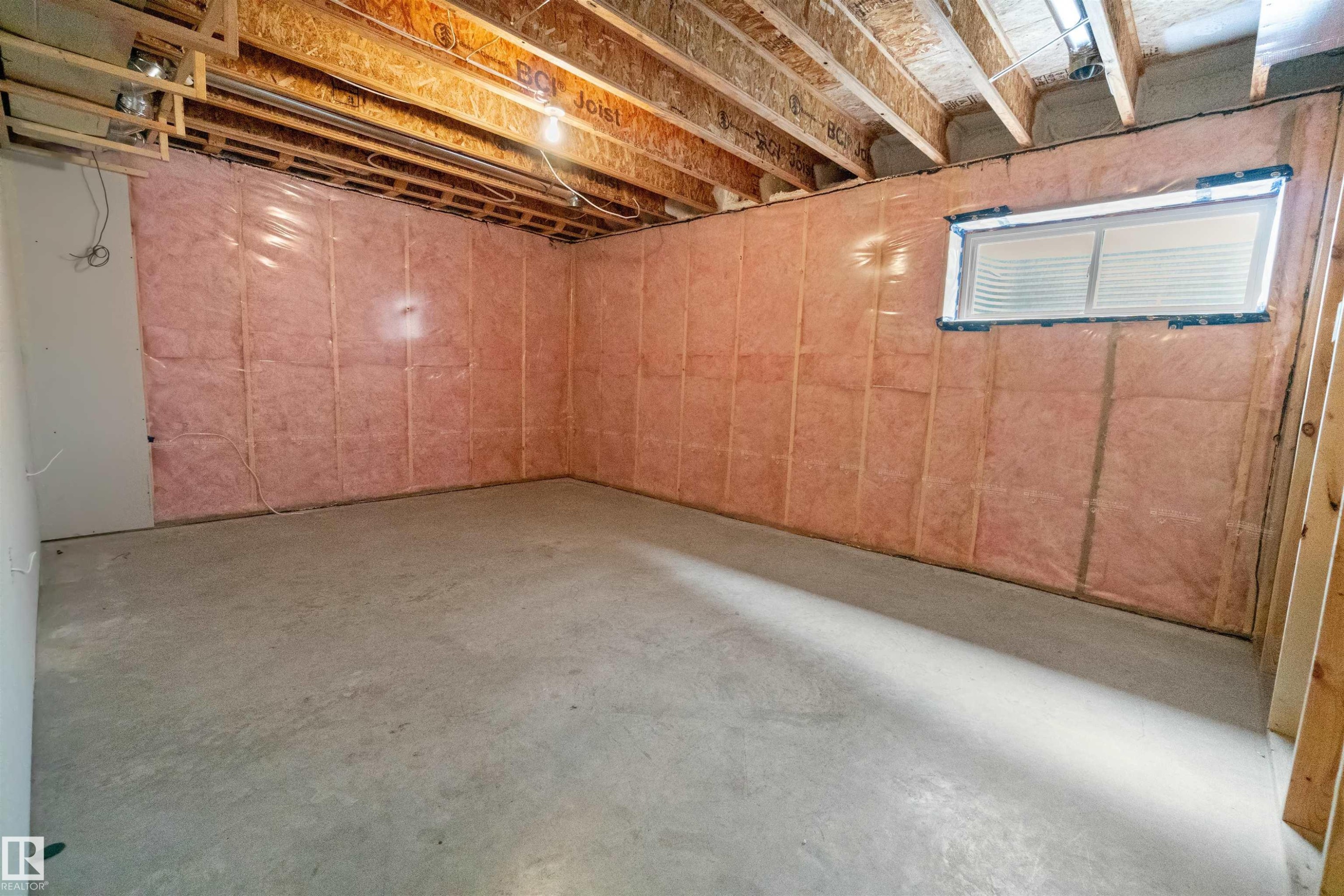 Unfinished basement space featuring exposed wooden joists, concrete flooring, and insulated walls - 97 Astoria Point(E), Devon, AB