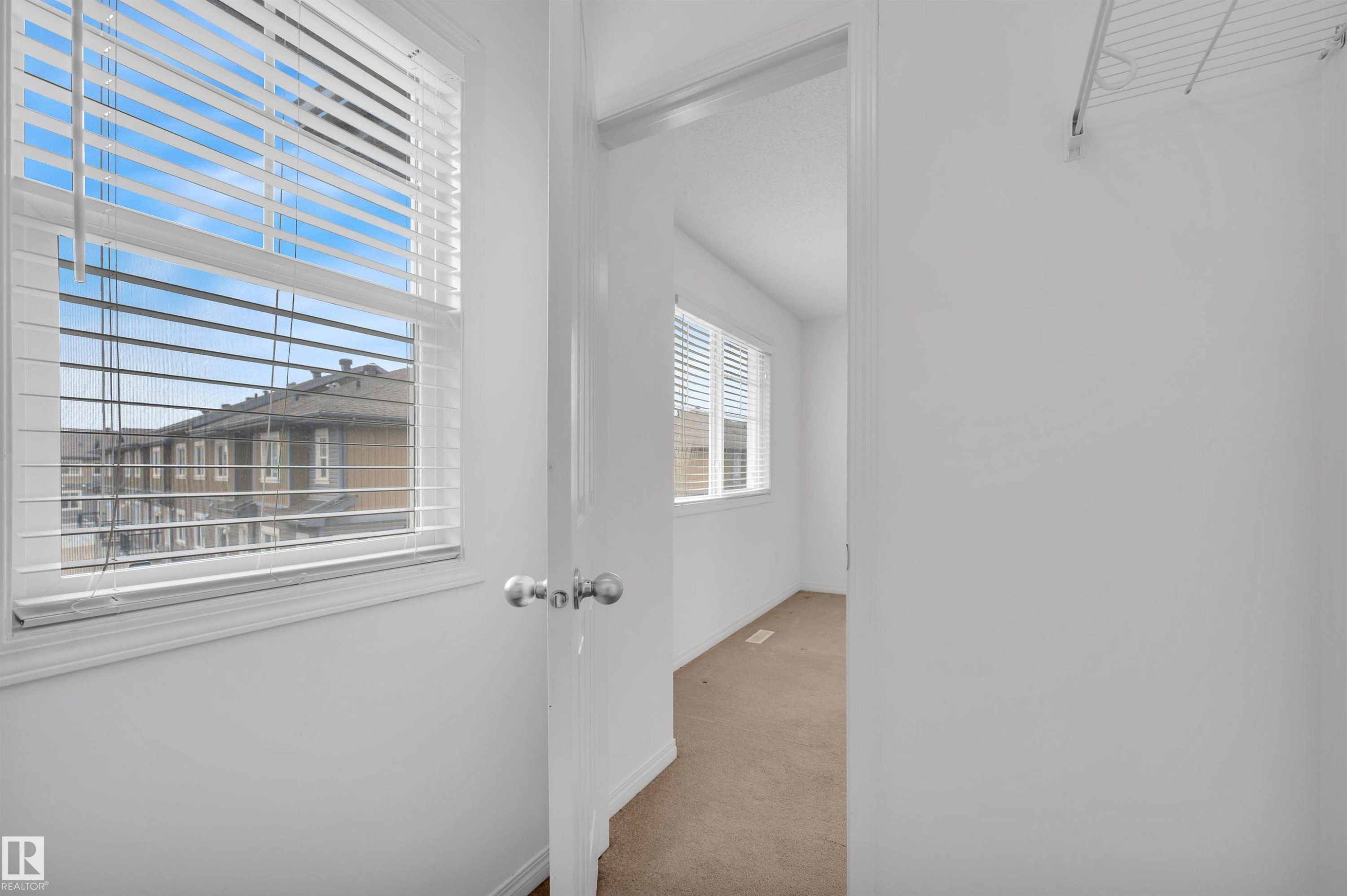 Window with white blinds, white trim, and a clear exterior view - 13 1030 Chappelle Boulevard, Edmonton, AB - Indoor Photo Showing Other Room