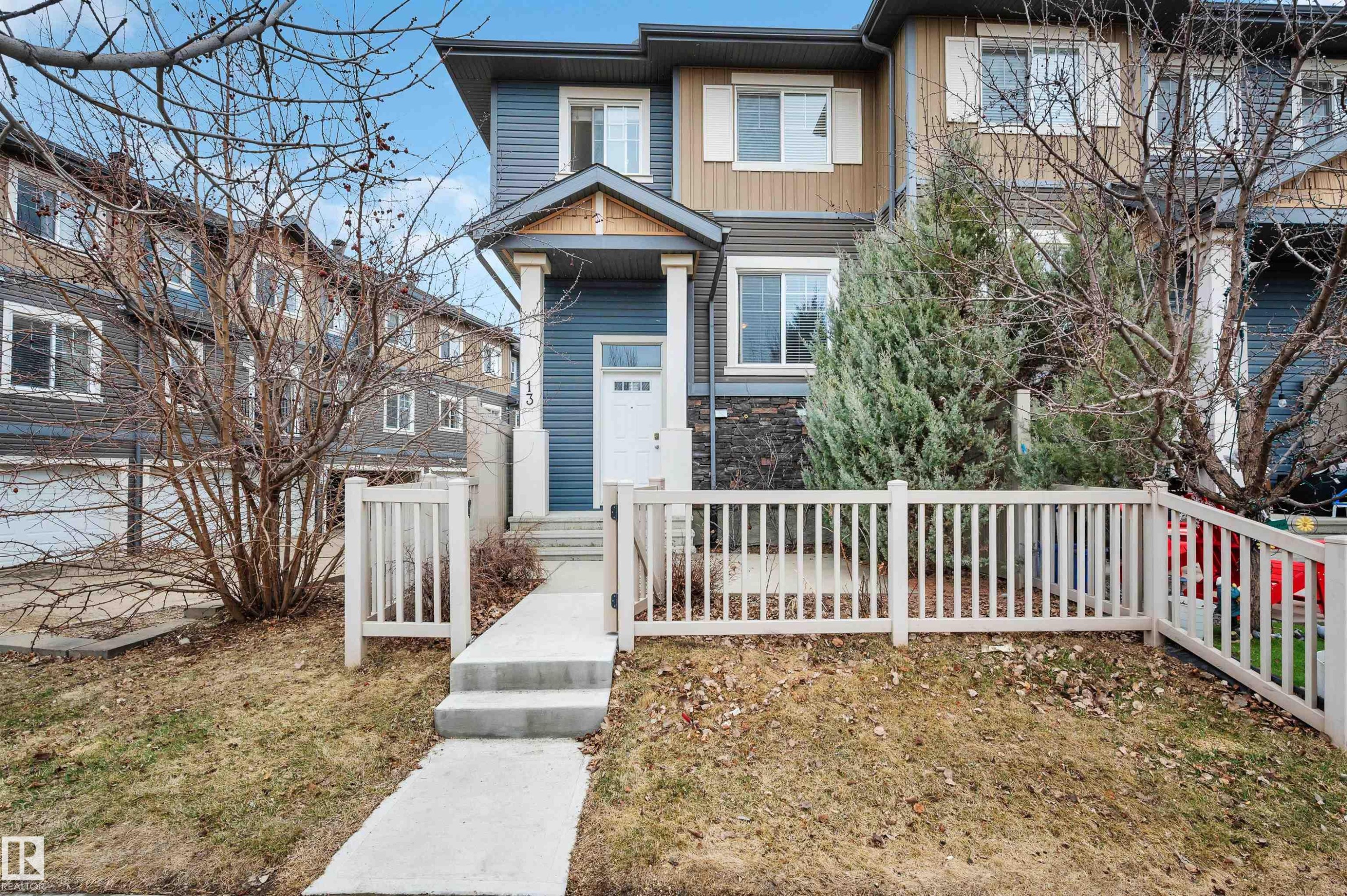 Contemporary townhome featuring blue and beige siding with stone accents - 13 1030 Chappelle Boulevard, Edmonton, AB - Outdoor With Facade