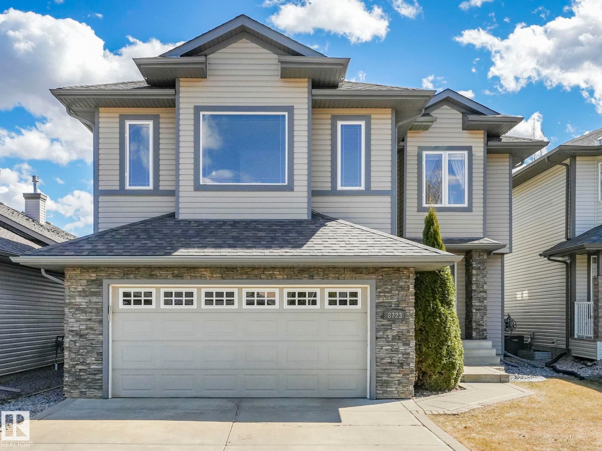 Contemporary multi-level exterior featuring light grey siding and dark grey trim accents - 8723 207 Street Nw, Edmonton, AB - Outdoor