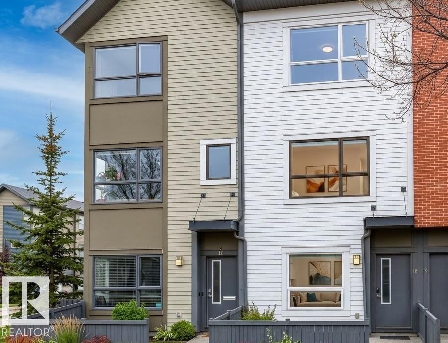 Contemporary townhome exteriors featuring multiple window styles, established landscaping, and a manicured lawn - 18, 2560 Pegasus Boulevard, Edmonton, AB - Outdoor