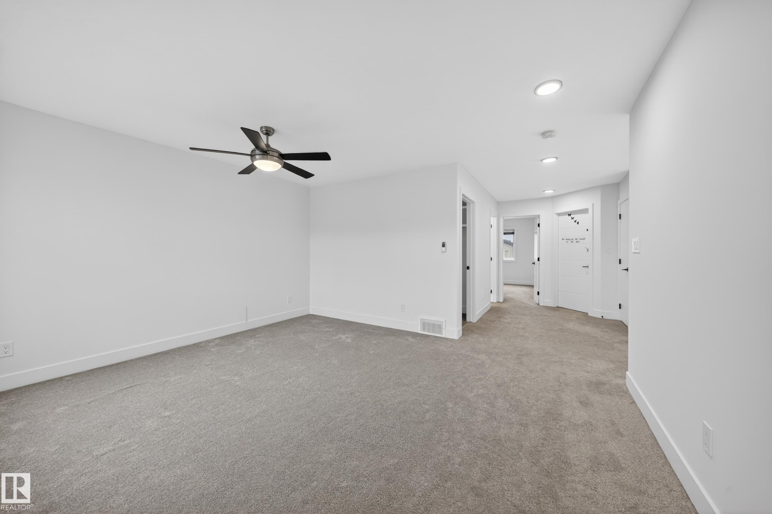 Spacious carpeted room with a ceiling fan, recessed lighting, white walls, and white baseboards - 7414 Chivers Crescent Sw, Edmonton, AB - Indoor Photo Showing Other Room