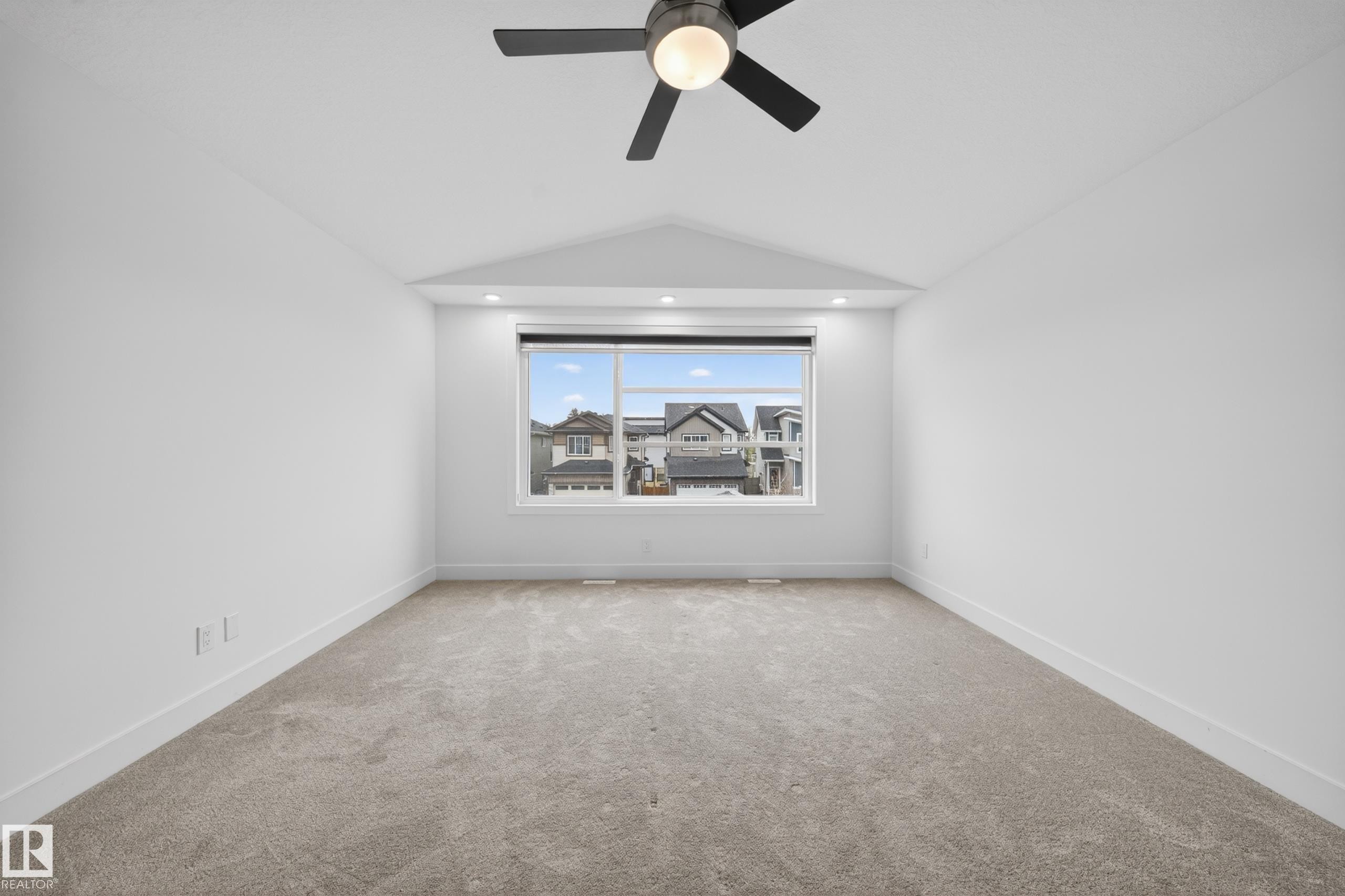 Spacious room with a large window, plush carpet flooring, recessed lighting, and a contemporary ceiling fan - 7414 Chivers Crescent Sw, Edmonton, AB - Indoor