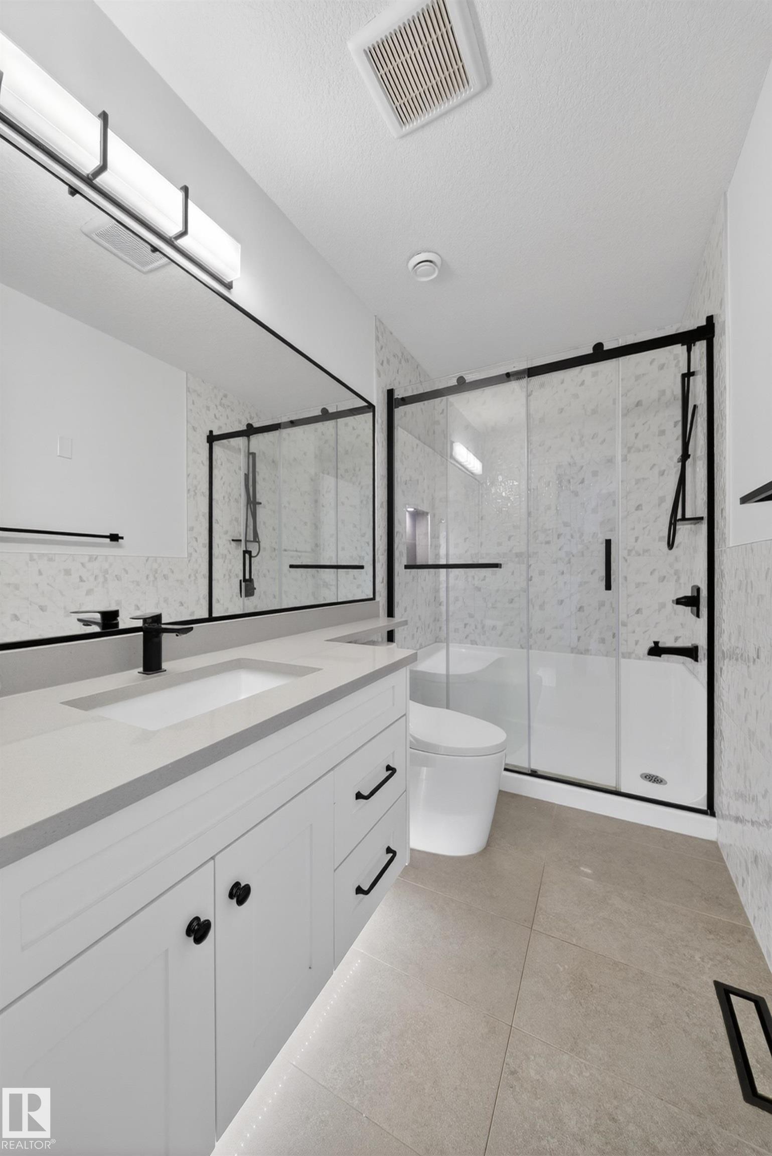 Contemporary bathroom featuring a white vanity with matte black hardware, integrated sink, and light gray countertop - 7414 Chivers Crescent Sw, Edmonton, AB - Indoor