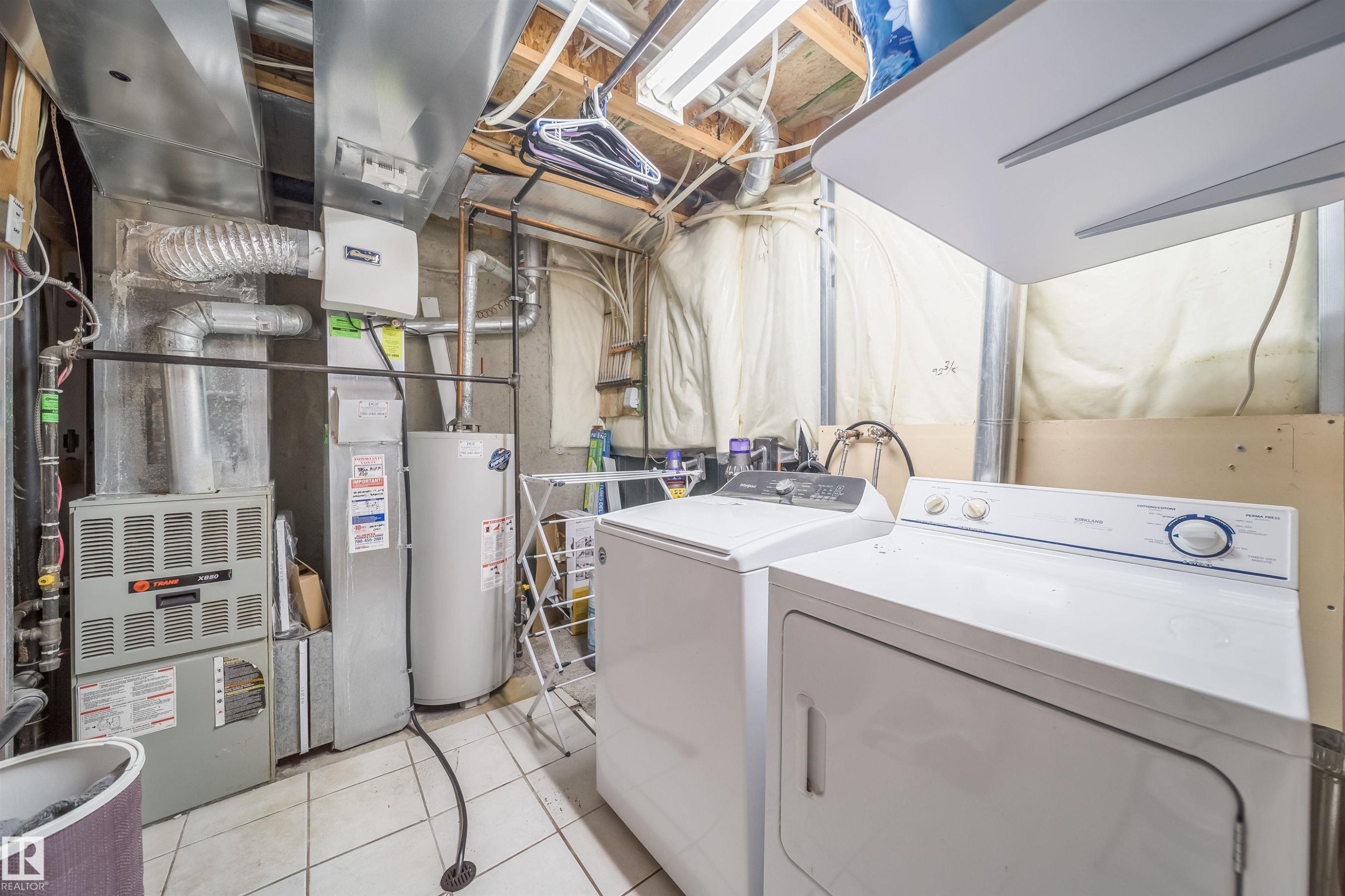 Dedicated utility space featuring a water heater, furnace, and laundry appliances - 50 14603 Miller Boulevard, Edmonton, AB