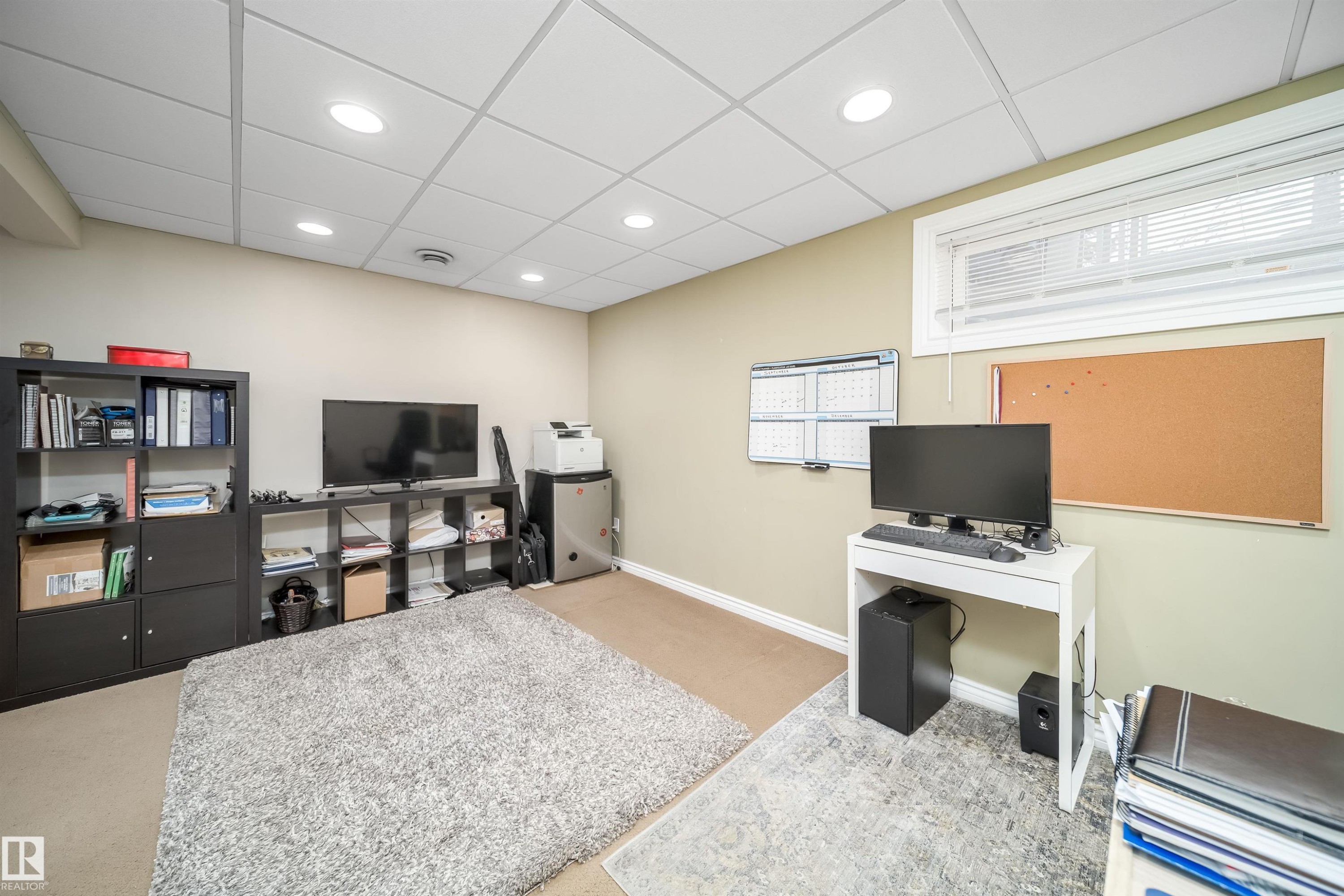 Versatile room featuring recessed lighting, a drop ceiling, and a window with blinds - 50 14603 Miller Boulevard, Edmonton, AB