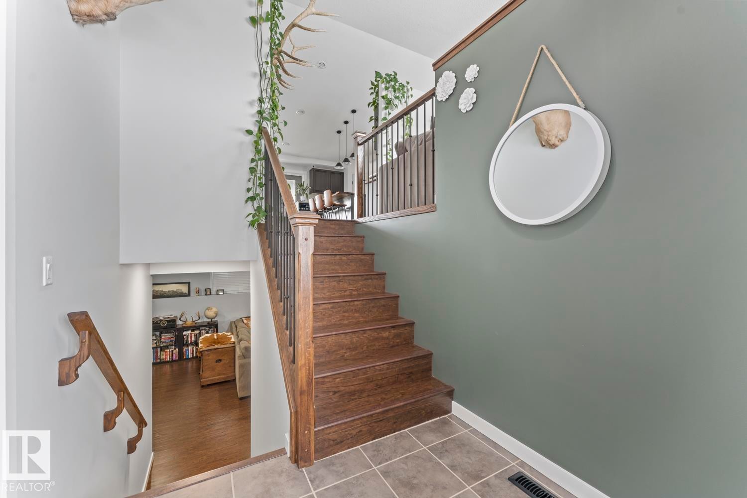 Split-level entry featuring wood-finish stairs with black metal spindles and a wood handrail - 4926 58 Ave, Cold Lake, AB - Indoor Photo Showing Other Room