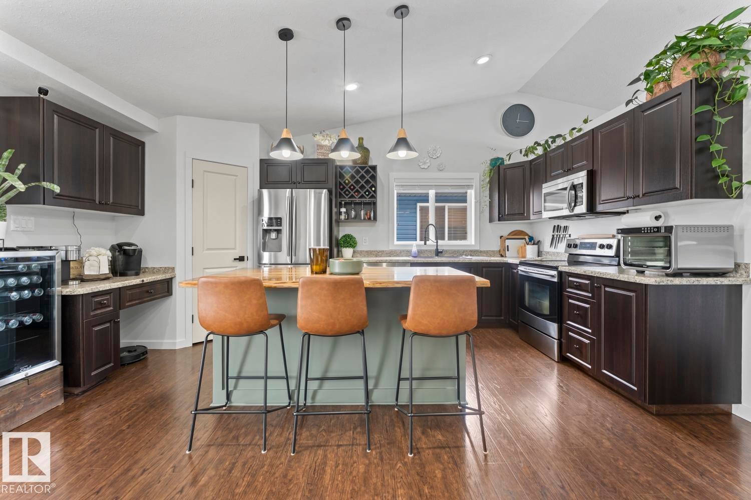 Kitchen featuring dark wood cabinetry, light-toned countertops, and wood-finish flooring - 4926 58 Ave, Cold Lake, AB - Indoor Photo Showing Kitchen With Upgraded Kitchen