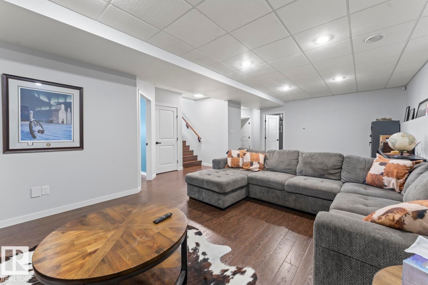 Spacious lower-level living area with recessed lighting, wood-finish flooring, and light gray walls - 4926 58 Ave, Cold Lake, AB - Indoor Photo Showing Living Room