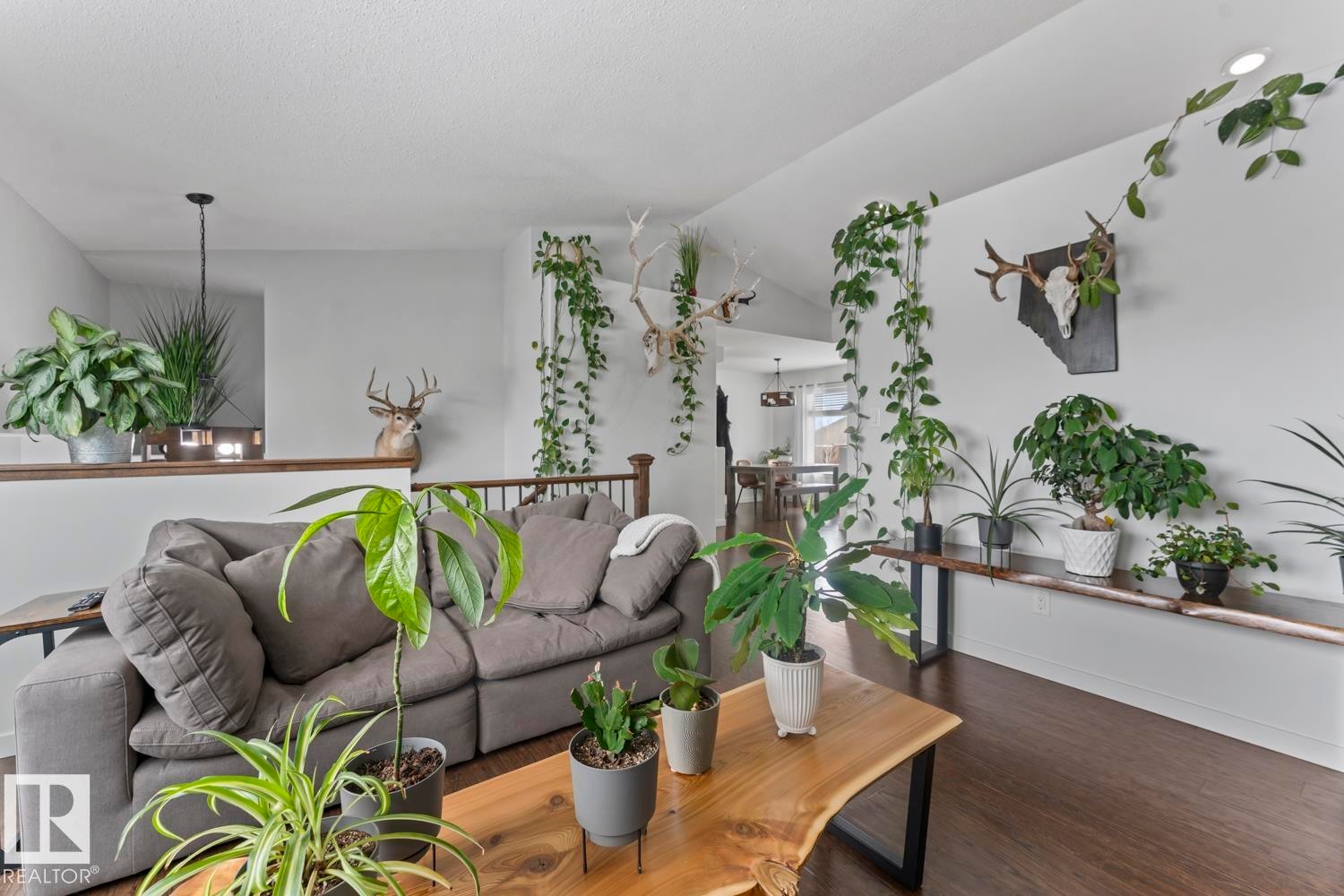 Living area featuring vaulted ceilings, wood-finish flooring, a wood-finish railing, and recessed lighting - 4926 58 Ave, Cold Lake, AB - Indoor Photo Showing Living Room