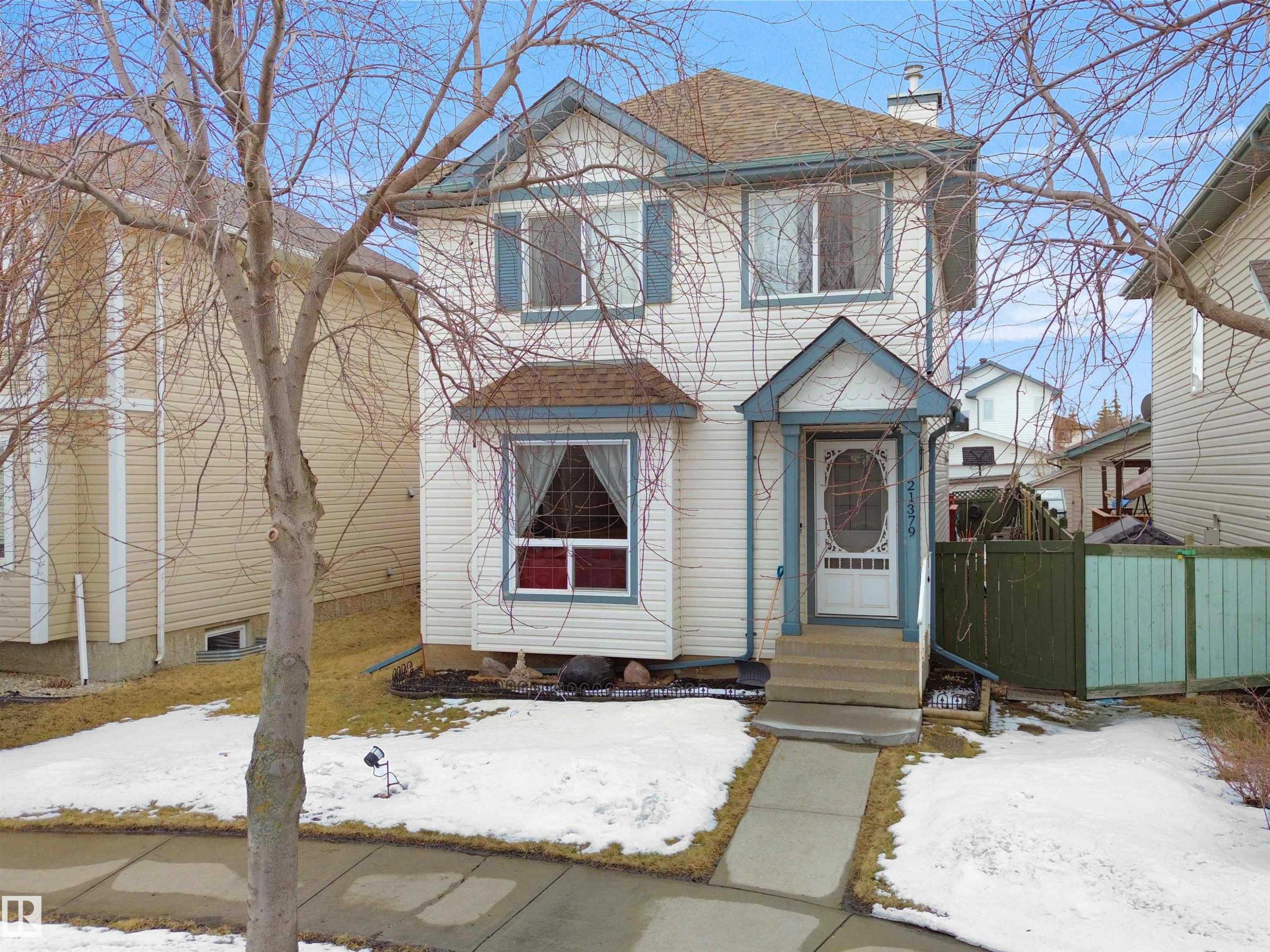 Two-story residence featuring light-colored siding with contrasting blue trim accents and shutters - 21379 89 Avenue Nw, Edmonton, AB - Outdoor