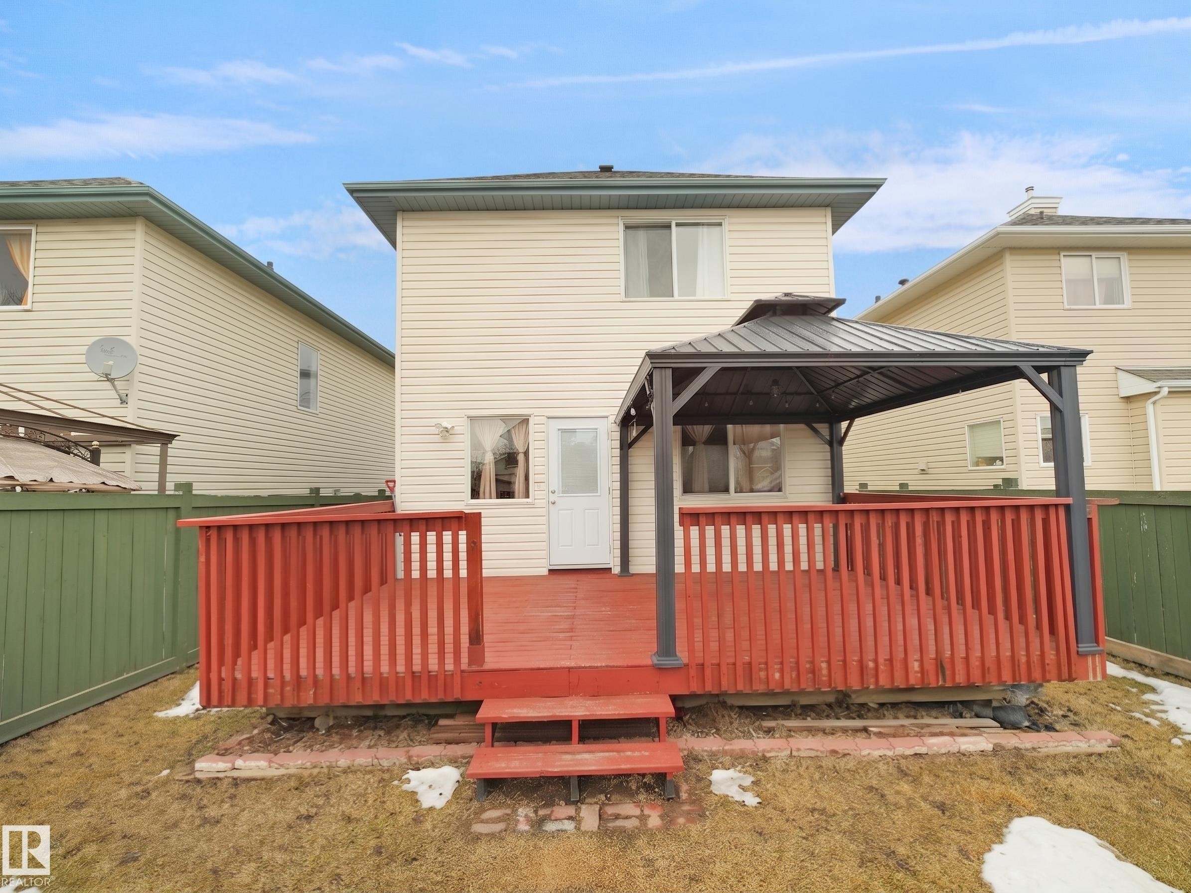 Exterior deck with red-stained wood and a metal-framed gazebo - 21379 89 Avenue Nw, Edmonton, AB - Outdoor With Exterior
