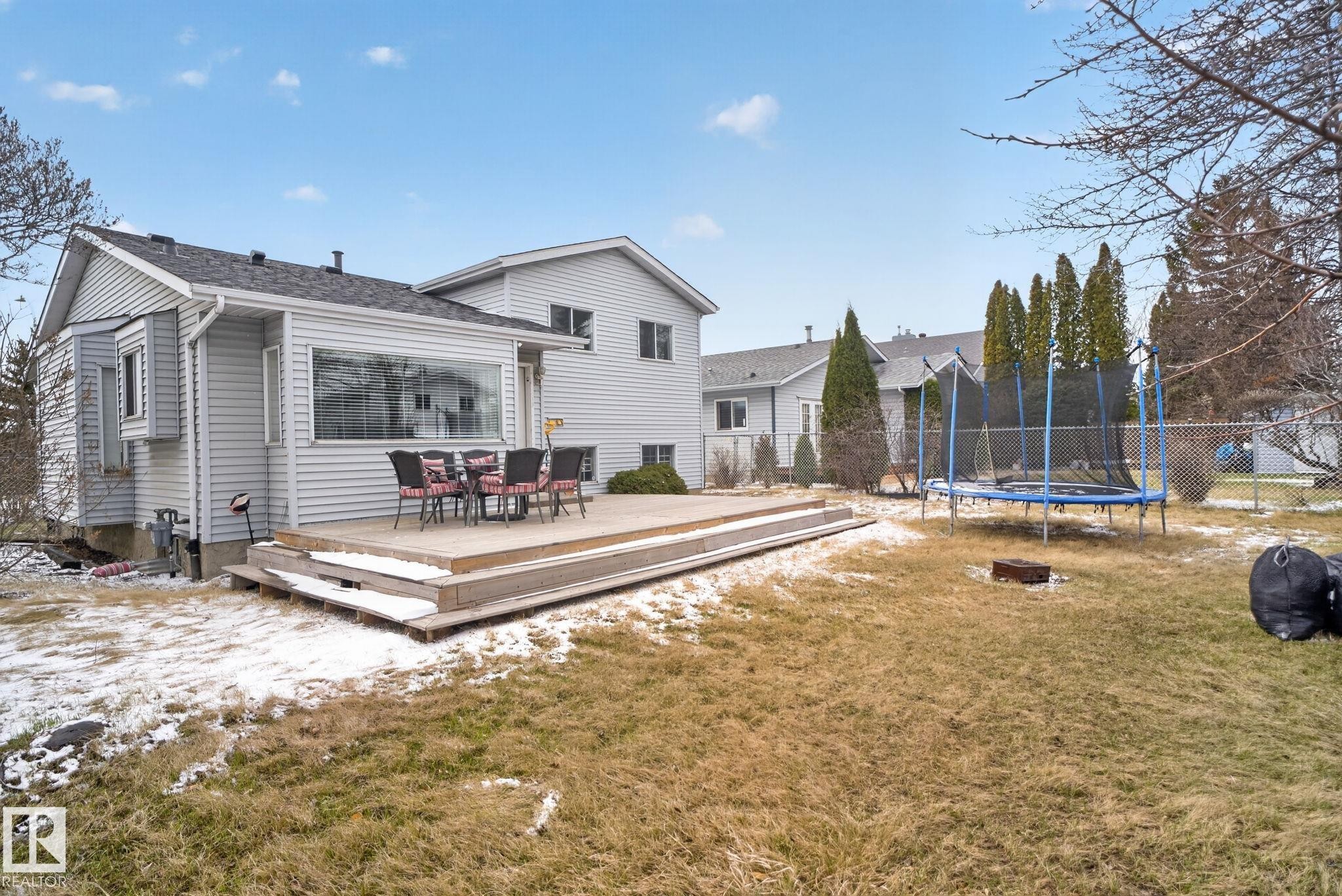 Rear exterior with light gray siding, featuring a multi-level wood-finish deck - 18604 97A Avenue, Edmonton, AB - Outdoor