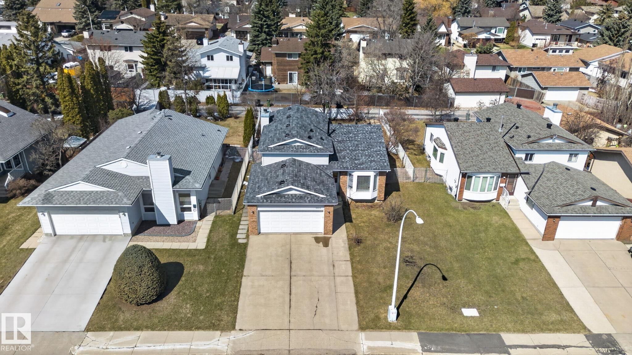 Front exterior featuring a dual-car garage, concrete driveway, and a bay window - 18604 97A Avenue, Edmonton, AB - Outdoor