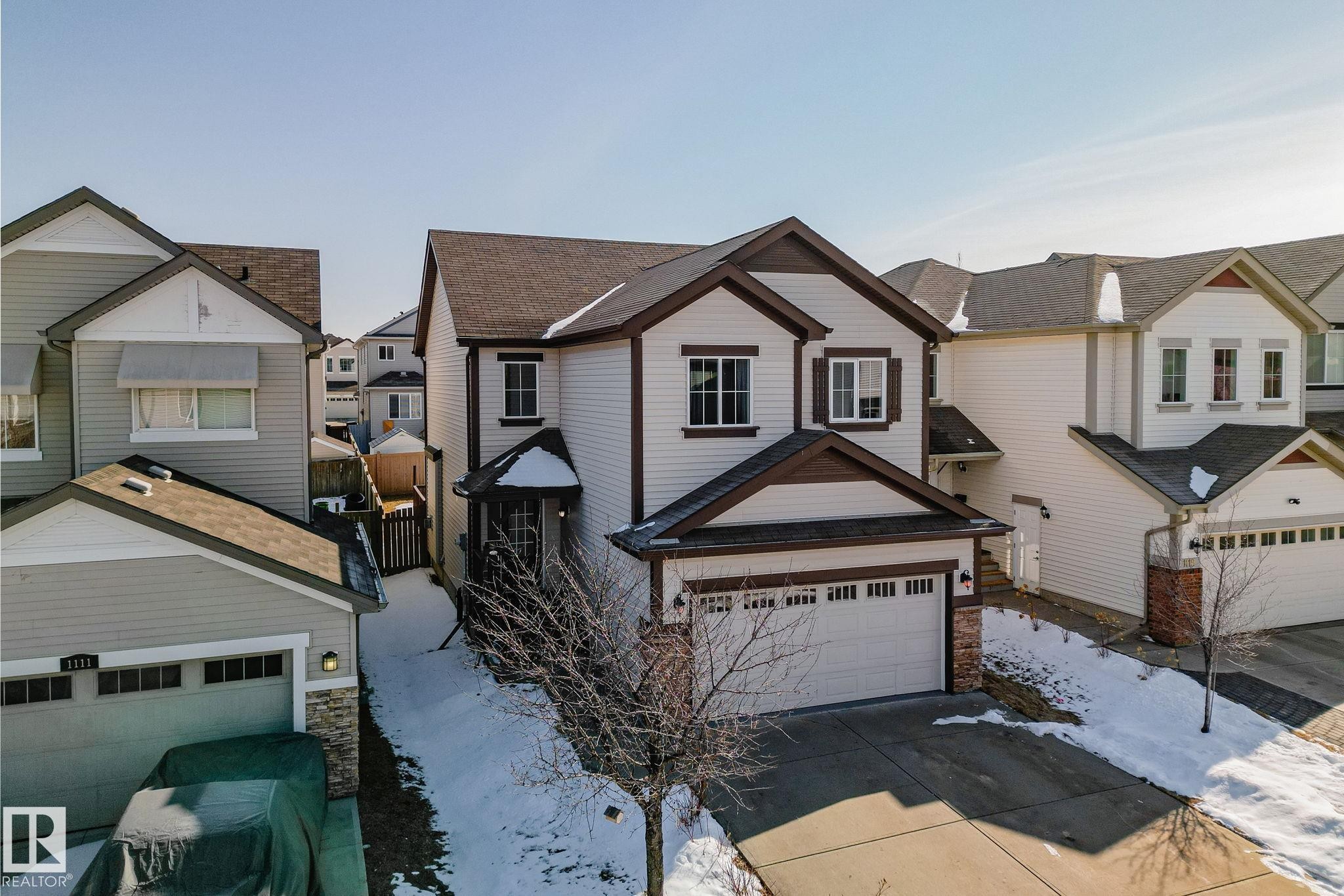 The property features a two-story design with light-colored siding and dark trim accents - 1115 61 Street, Edmonton, AB - Outdoor With Facade