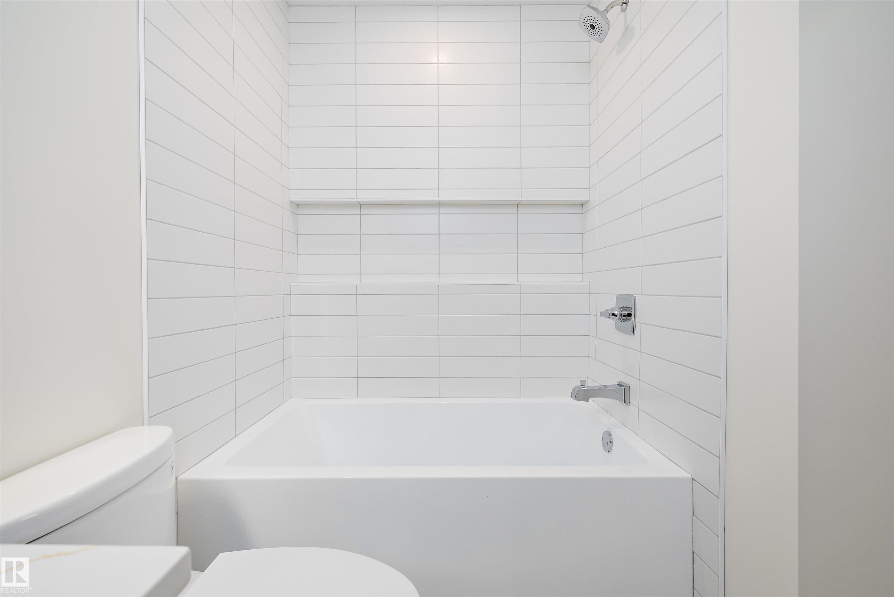 Contemporary bathtub with white subway tile surround, chrome fixtures, and an integrated shower niche - 11418 96 Street, Edmonton, AB - Indoor Photo Showing Bathroom