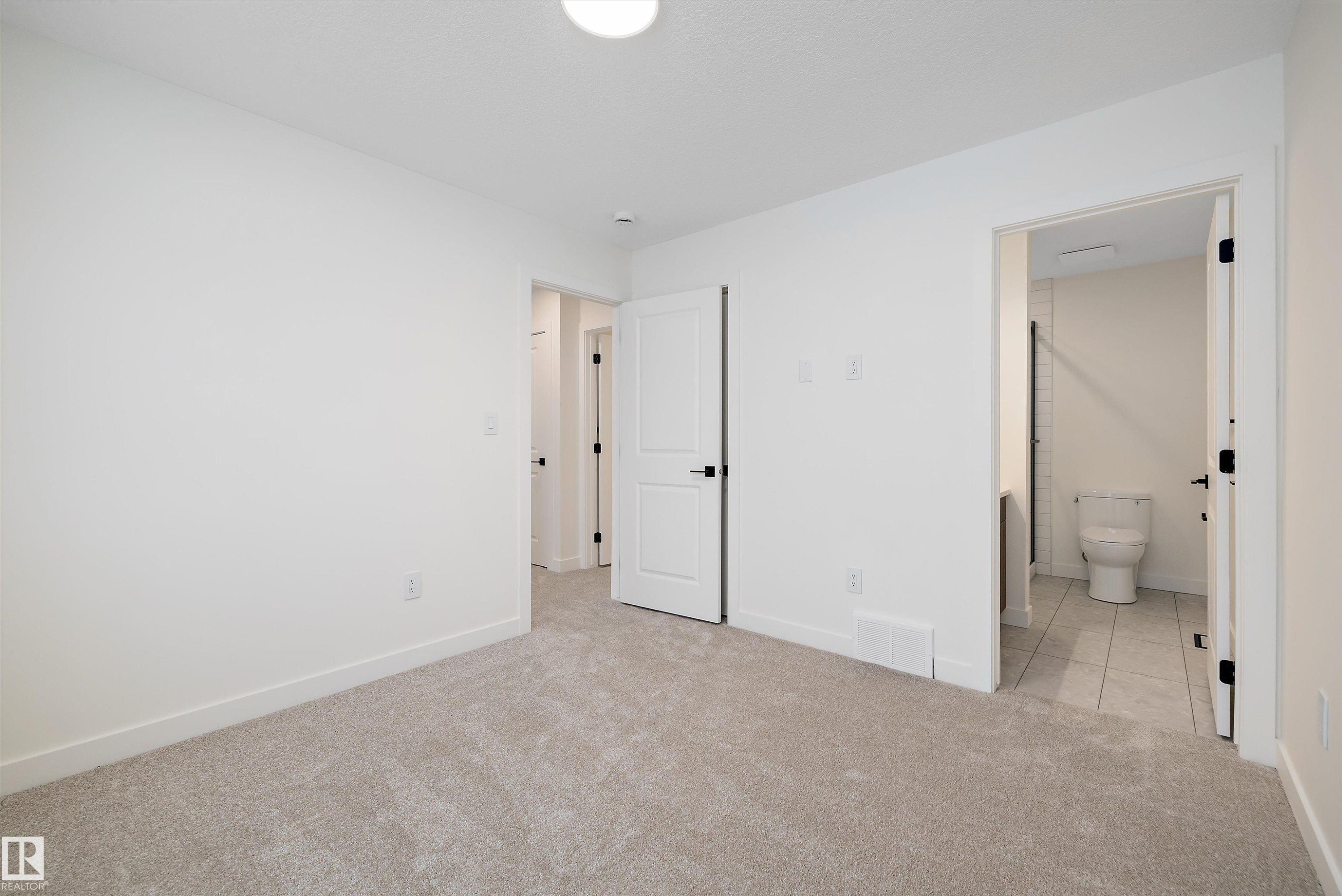 Light-toned carpeting in a neutral room with white walls and baseboards - 11418 96 Street, Edmonton, AB - Indoor Photo Showing Other Room