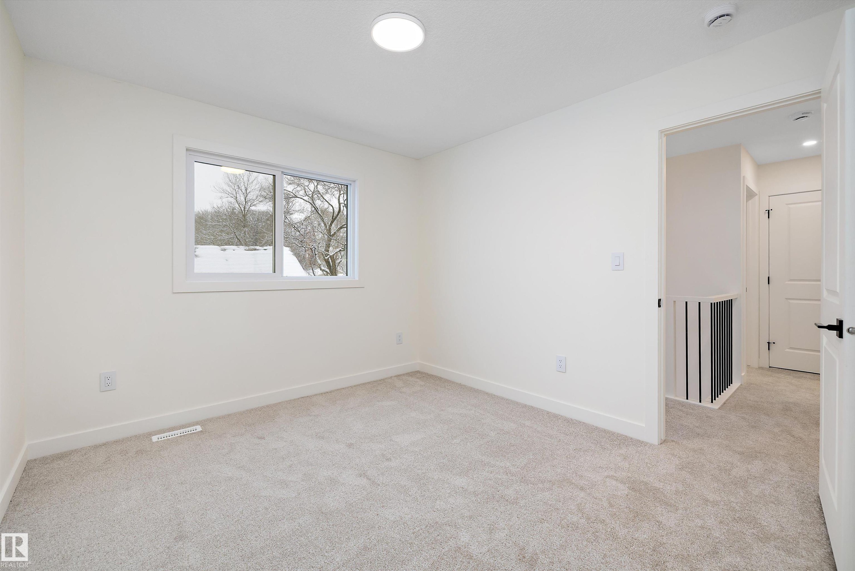 Carpeted room featuring a white-framed window, recessed lighting, and a neutral color palette - 11418 96 Street, Edmonton, AB - Indoor Photo Showing Other Room