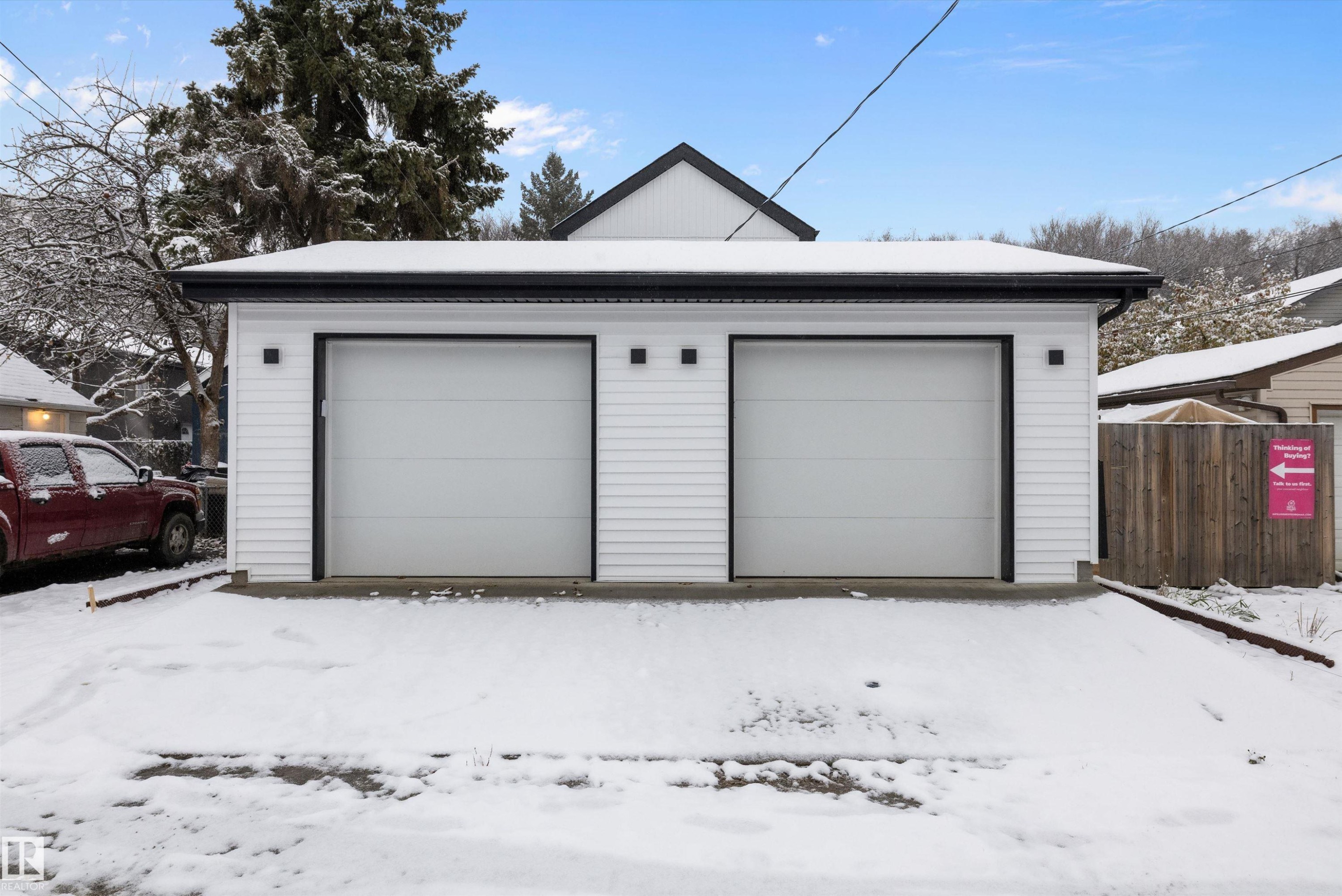 Detached two-car garage featuring white horizontal siding, black trim, and two individual overhead doors - 11418 96 Street, Edmonton, AB - Outdoor With Exterior