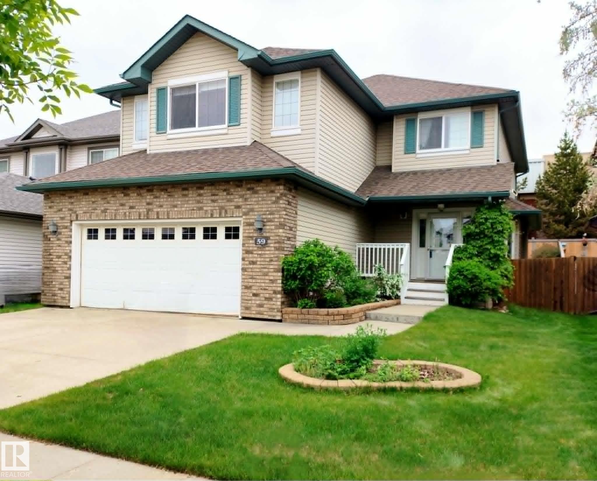Two-story residence featuring a brick facade on the lower level and siding on the upper level - 59 Rue Monette, Beaumont, AB