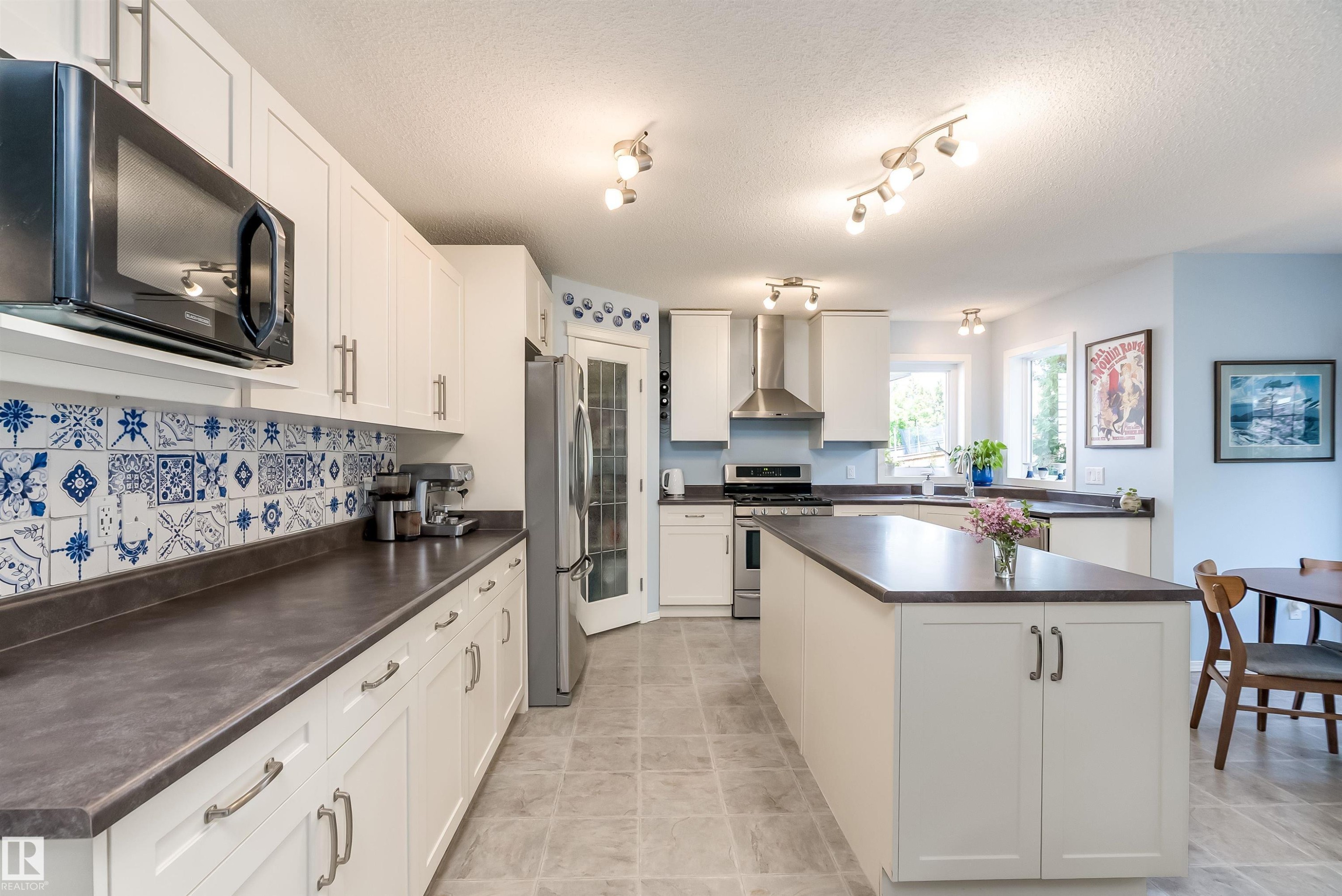 Carpeted room featuring a ceiling fan with integrated lighting, two windows with window treatments, and a wall with contrasting paint - 59 Rue Monette, Beaumont, AB