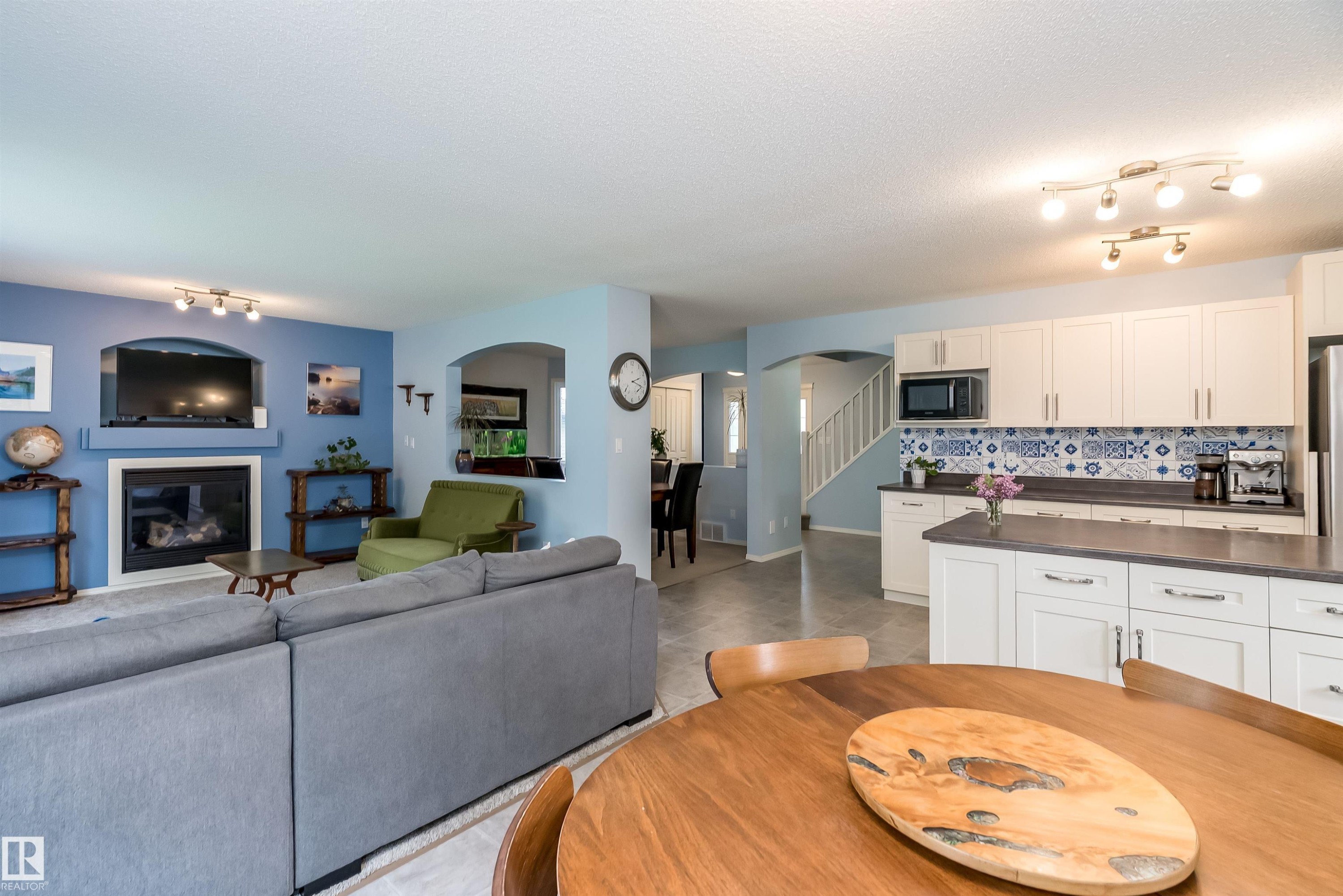 Spacious interior with neutral carpeting and a map-covered accent wall - 59 Rue Monette, Beaumont, AB
