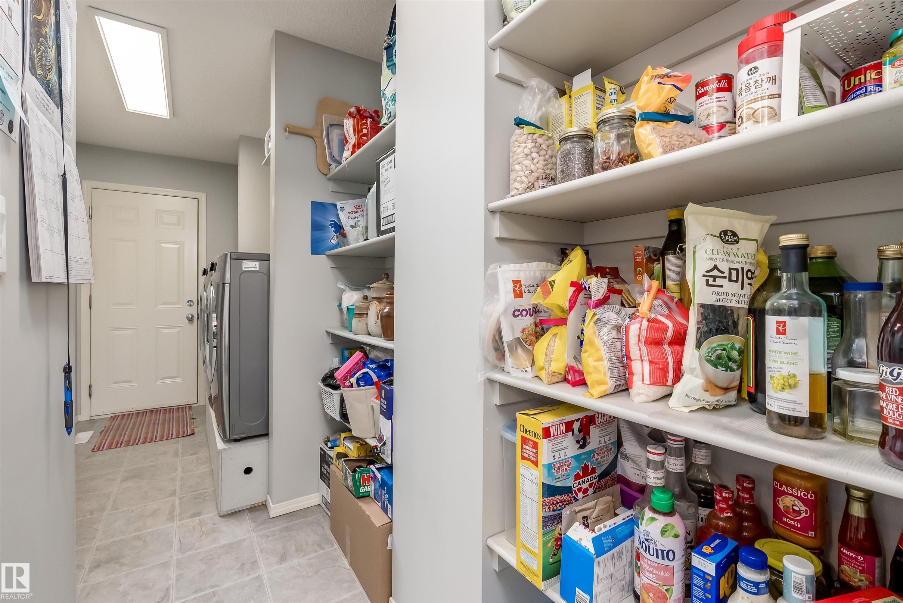 Spacious room featuring multiple windows with white trim, a ceiling fan with integrated lighting, and carpeted flooring - 59 Rue Monette, Beaumont, AB