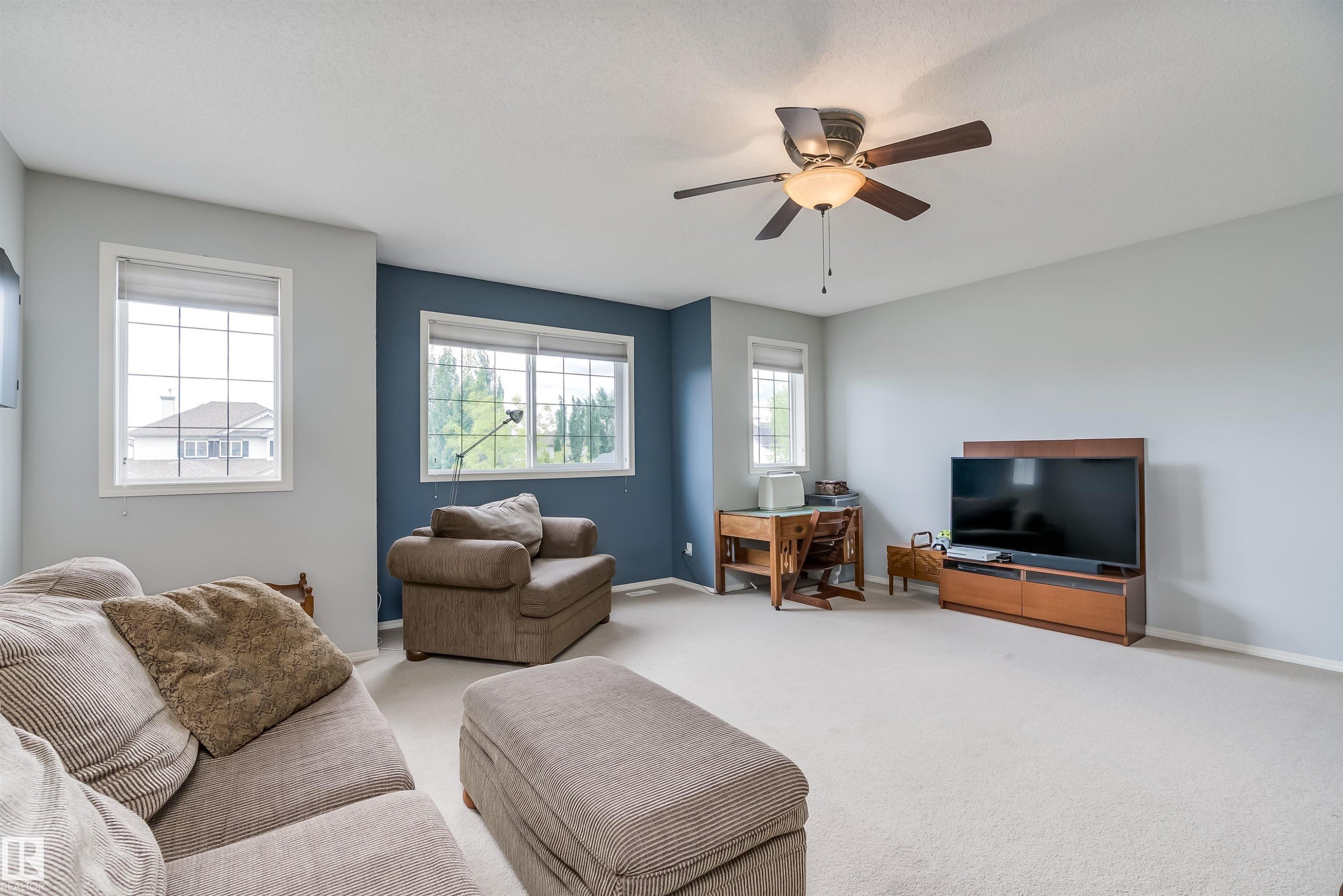 Wall-to-wall carpeting with a large window featuring a white frame - 59 Rue Monette, Beaumont, AB