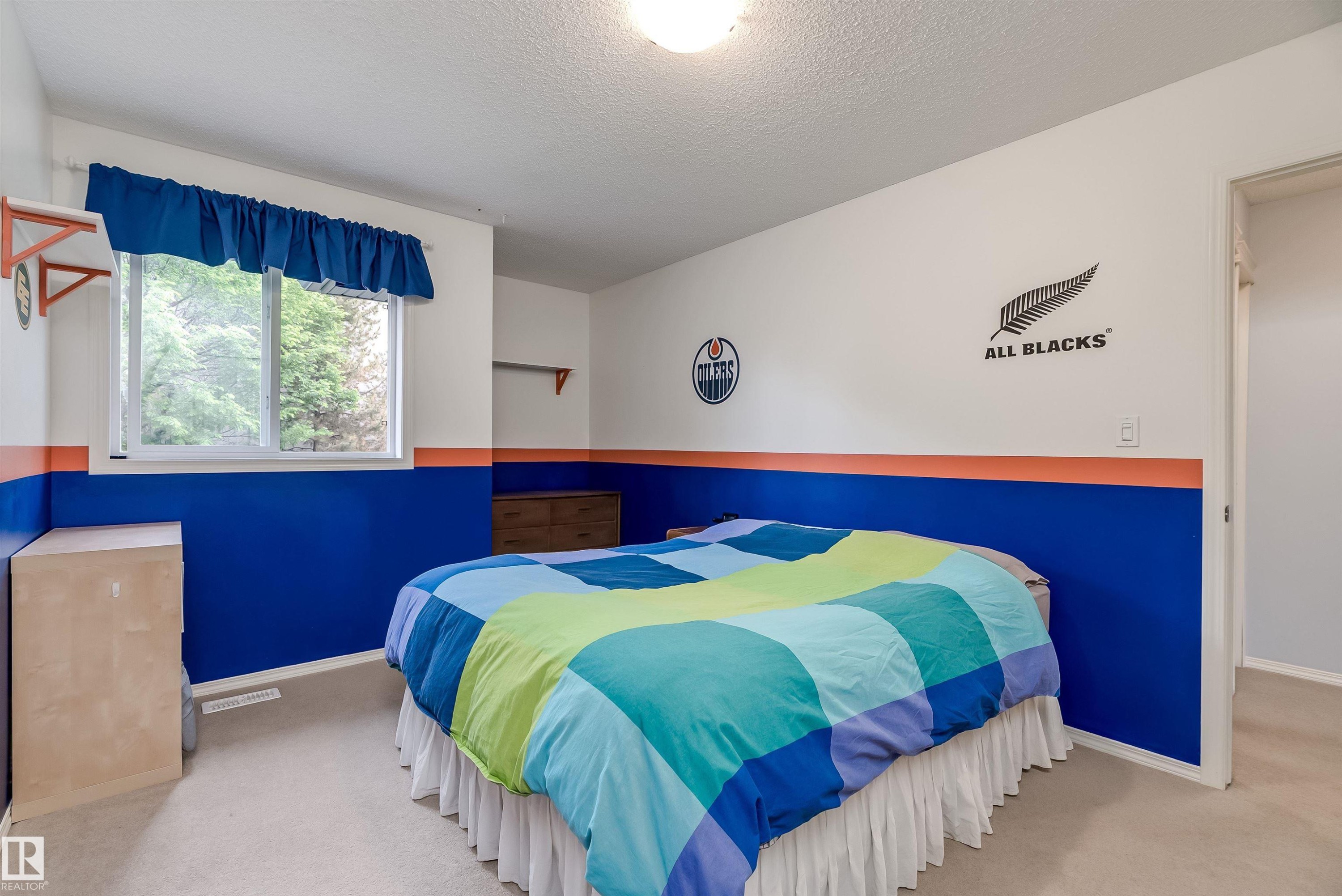 Spacious backyard featuring a large deck with built-in pergola, gravel pit area, well maintained lawn and a hot tub - 59 Rue Monette, Beaumont, AB