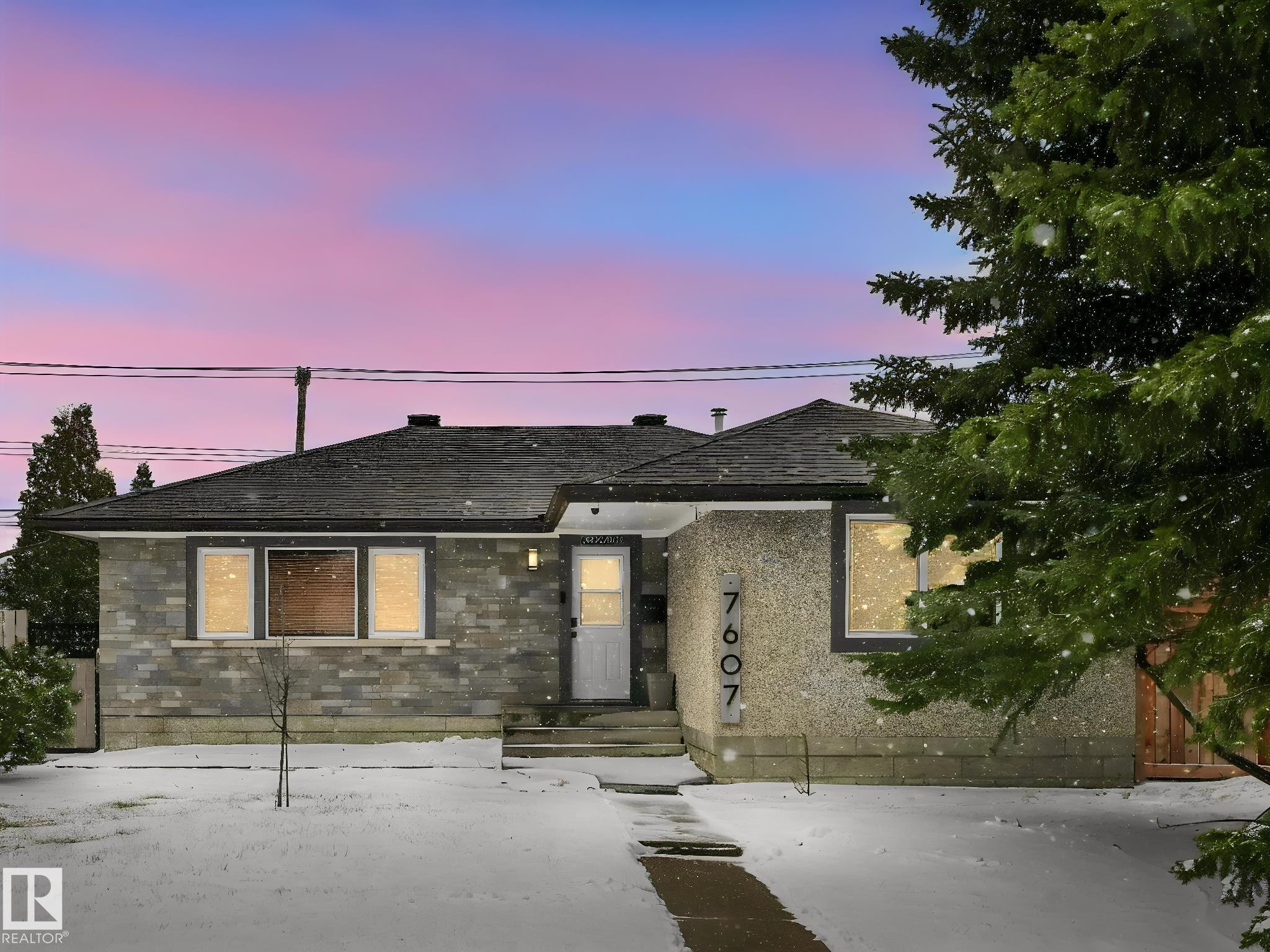 Contemporary ranch-style residence featuring a gray stacked stone facade and dark shingle roofing - 7607 70 Avenue, Edmonton, AB - Outdoor