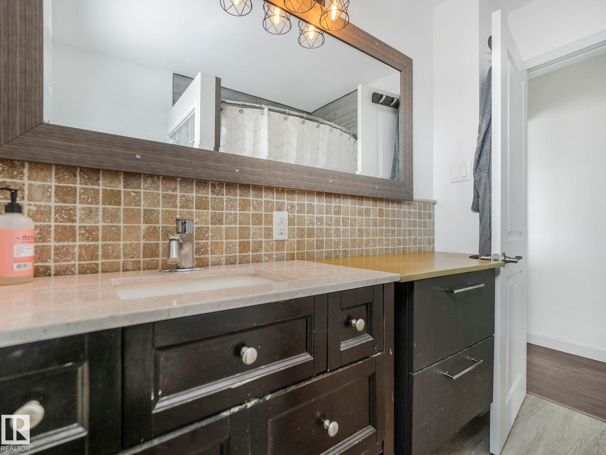 Vanity with integrated sink, chrome faucet, and light-colored countertop - 7607 70 Avenue, Edmonton, AB - Indoor