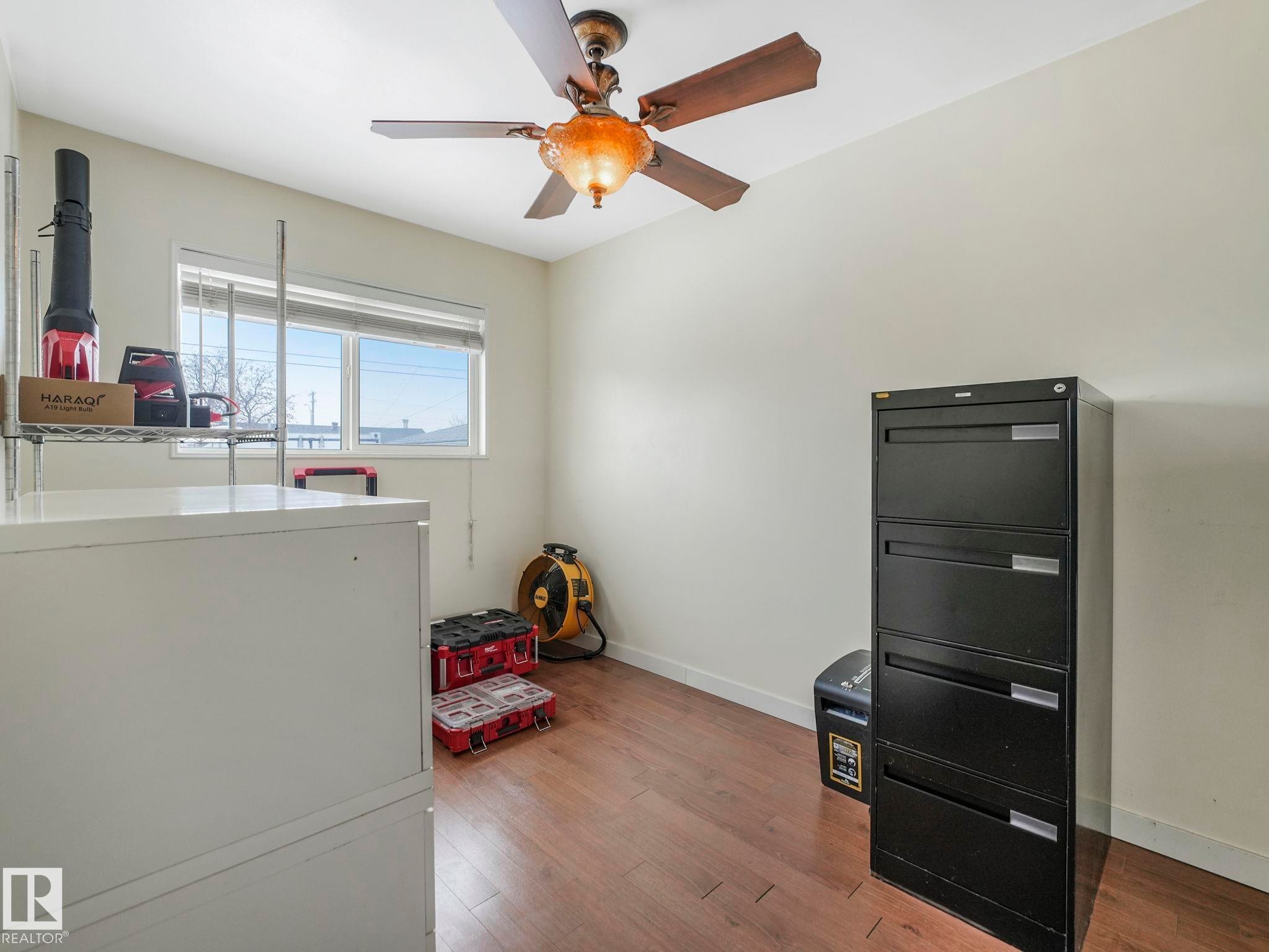 Ceiling fan with integrated lighting, and a single window with blinds. Presently used as storage area. - 7607 70 Avenue, Edmonton, AB - Indoor