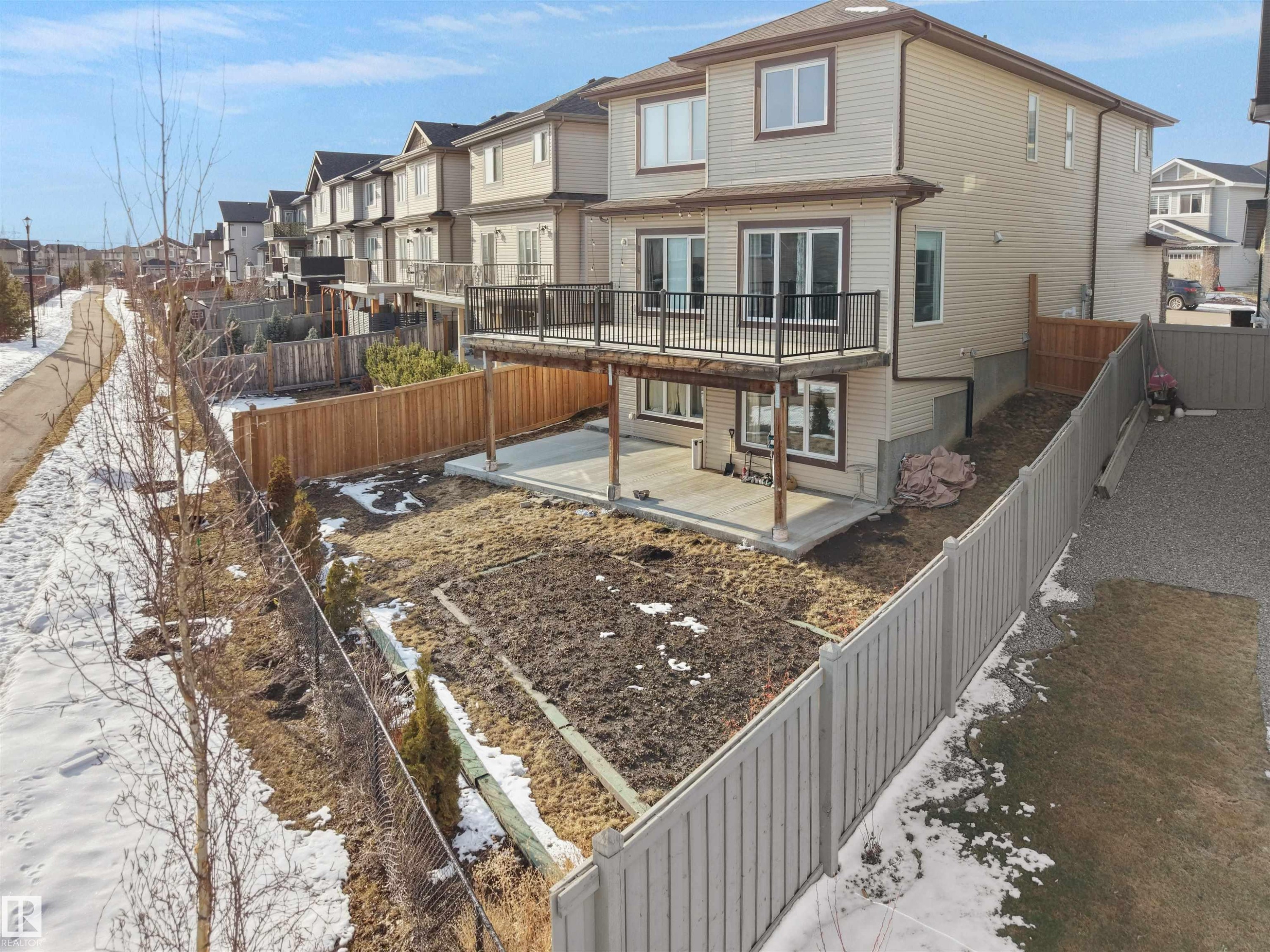 The property features a private backyard with a fenced perimeter and a spacious deck accessed via sliding glass doors - 4231 Charles Close, Edmonton, AB - Outdoor With Deck Patio Veranda