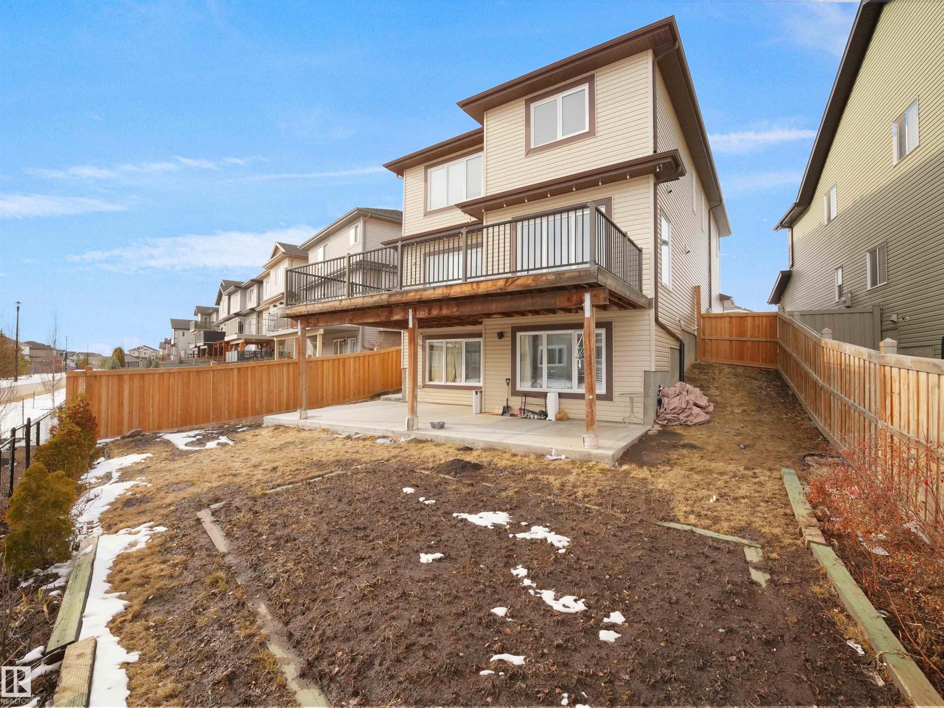 The property features a multi-level structure with beige siding and brown trim - 4231 Charles Close, Edmonton, AB - Outdoor With Deck Patio Veranda