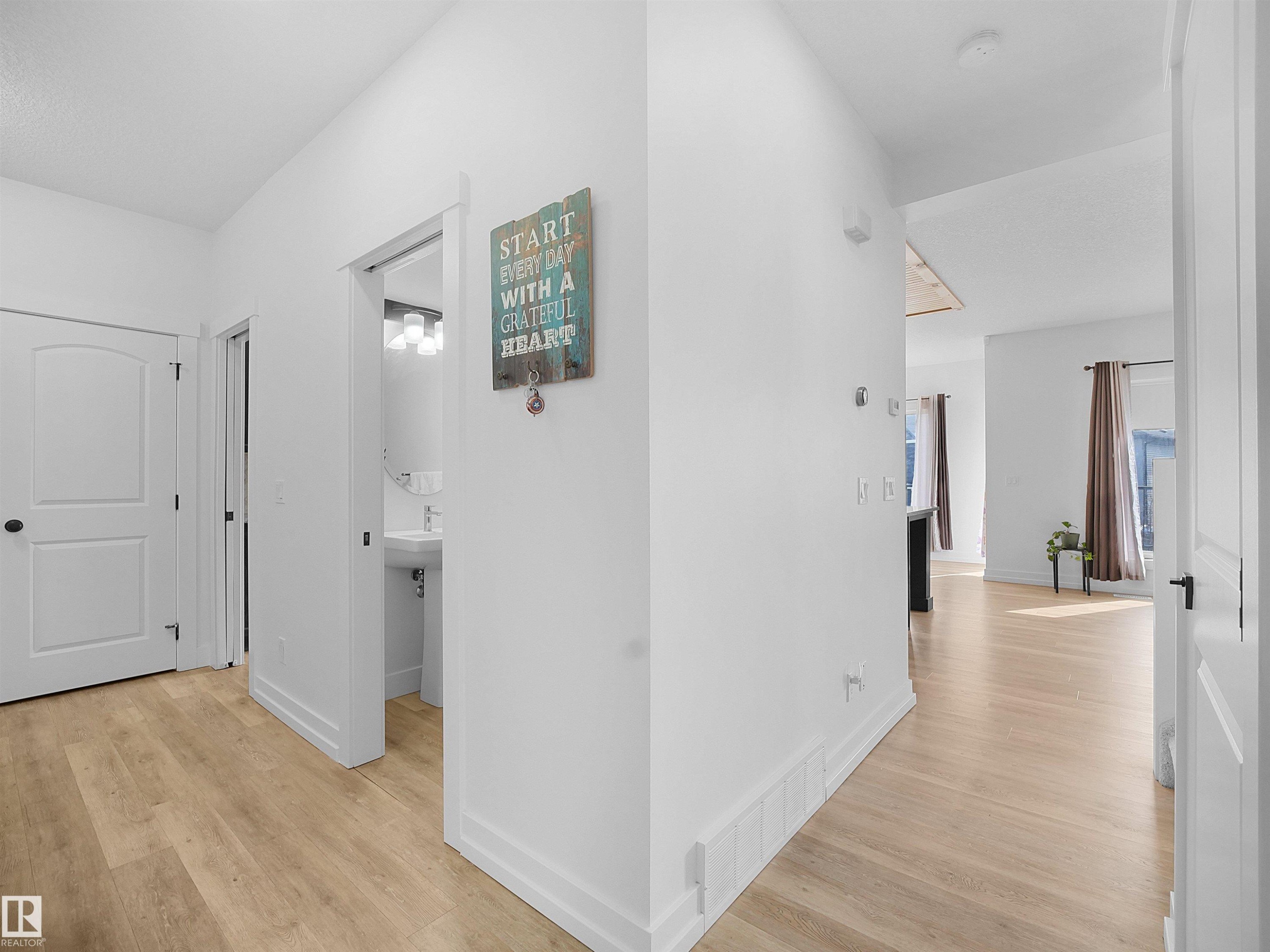 The property features light-colored flooring, white interior doors, and a well-lit hall with a view into another room - 4231 Charles Close, Edmonton, AB - Indoor Photo Showing Other Room