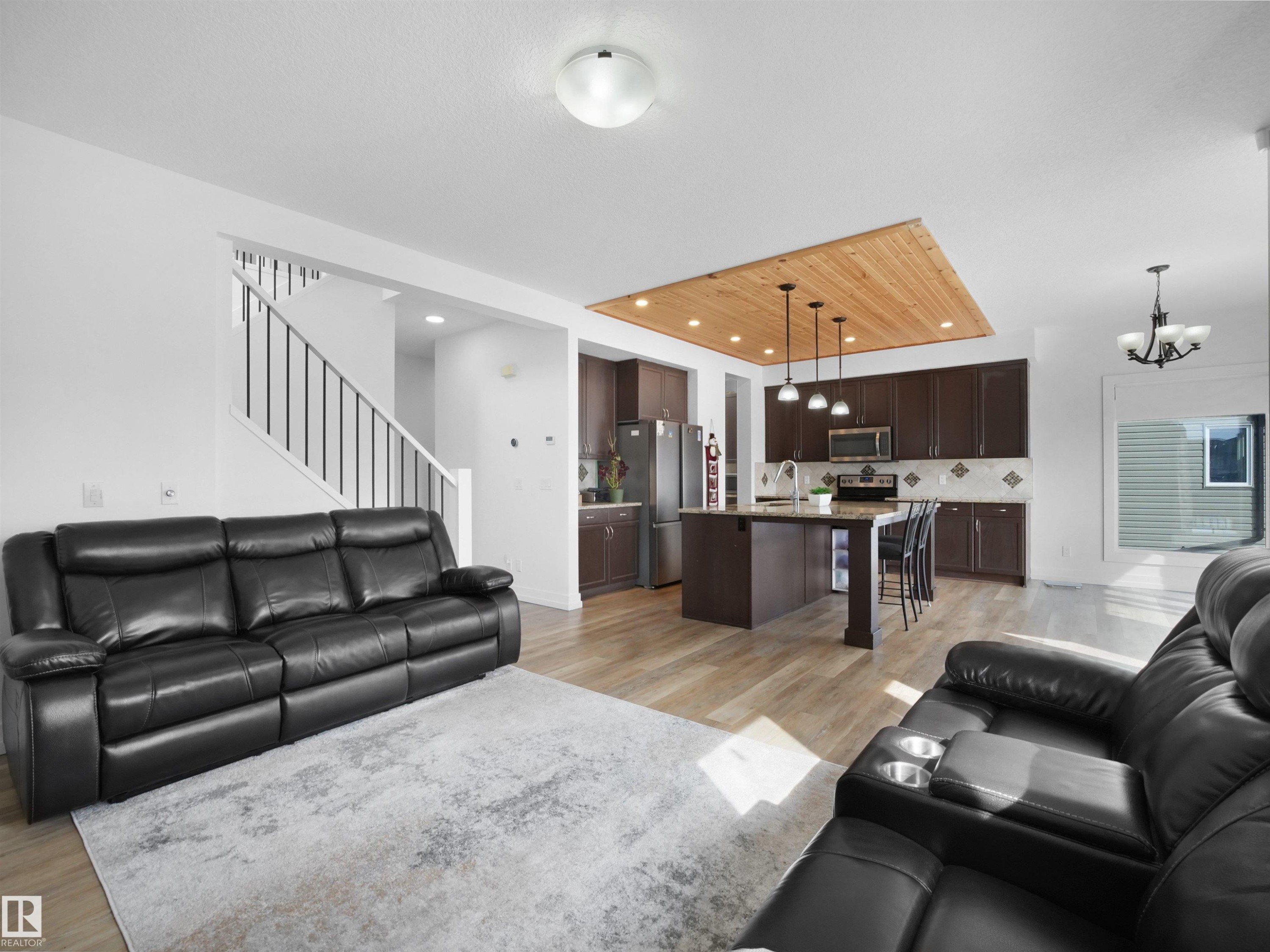 The property features an open-concept living area with light-toned flooring and white walls - 4231 Charles Close, Edmonton, AB - Indoor Photo Showing Living Room