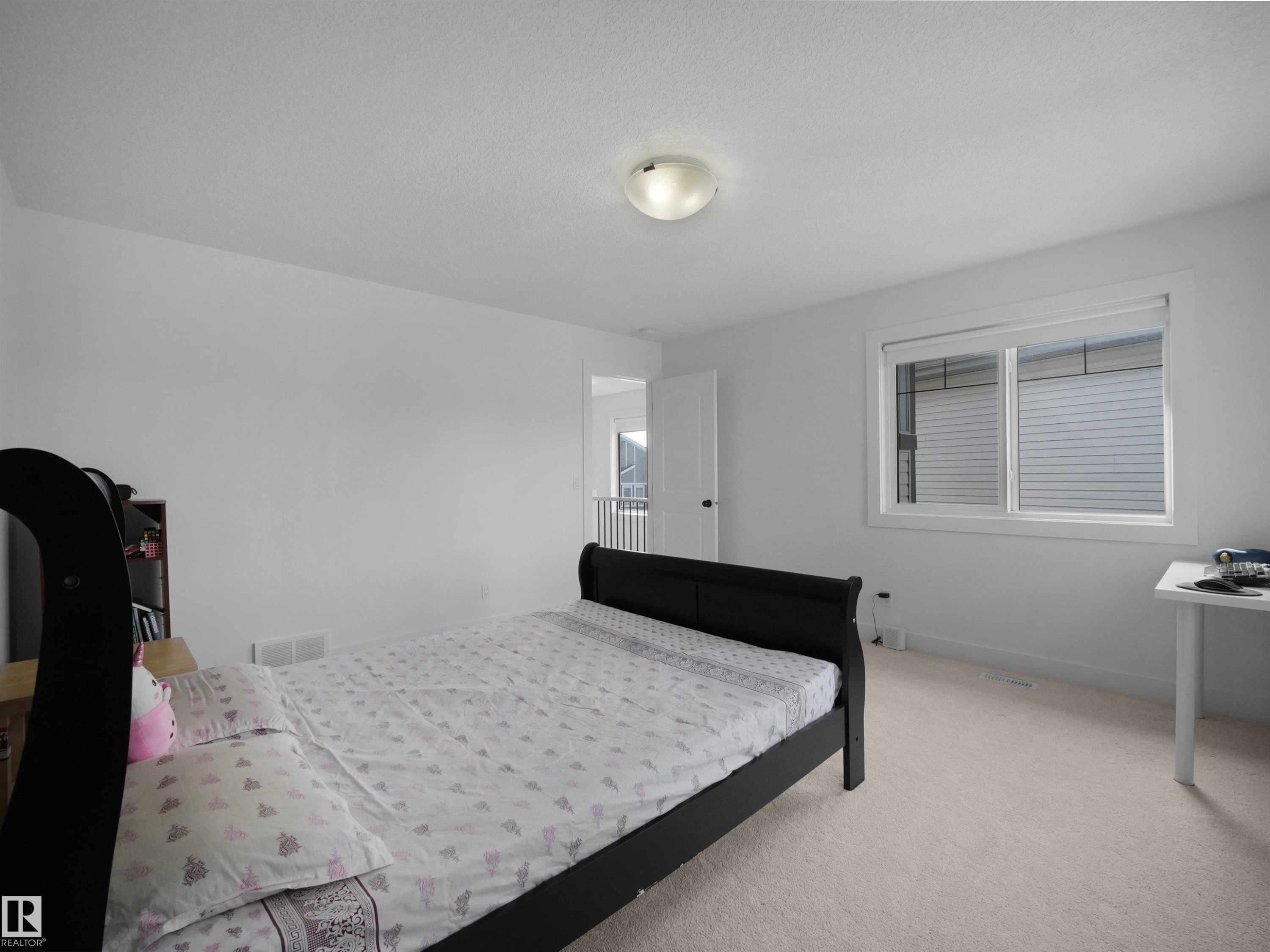 This room features light-colored carpeting, a window with blinds, and a ceiling light fixture - 4231 Charles Close, Edmonton, AB - Indoor Photo Showing Bedroom