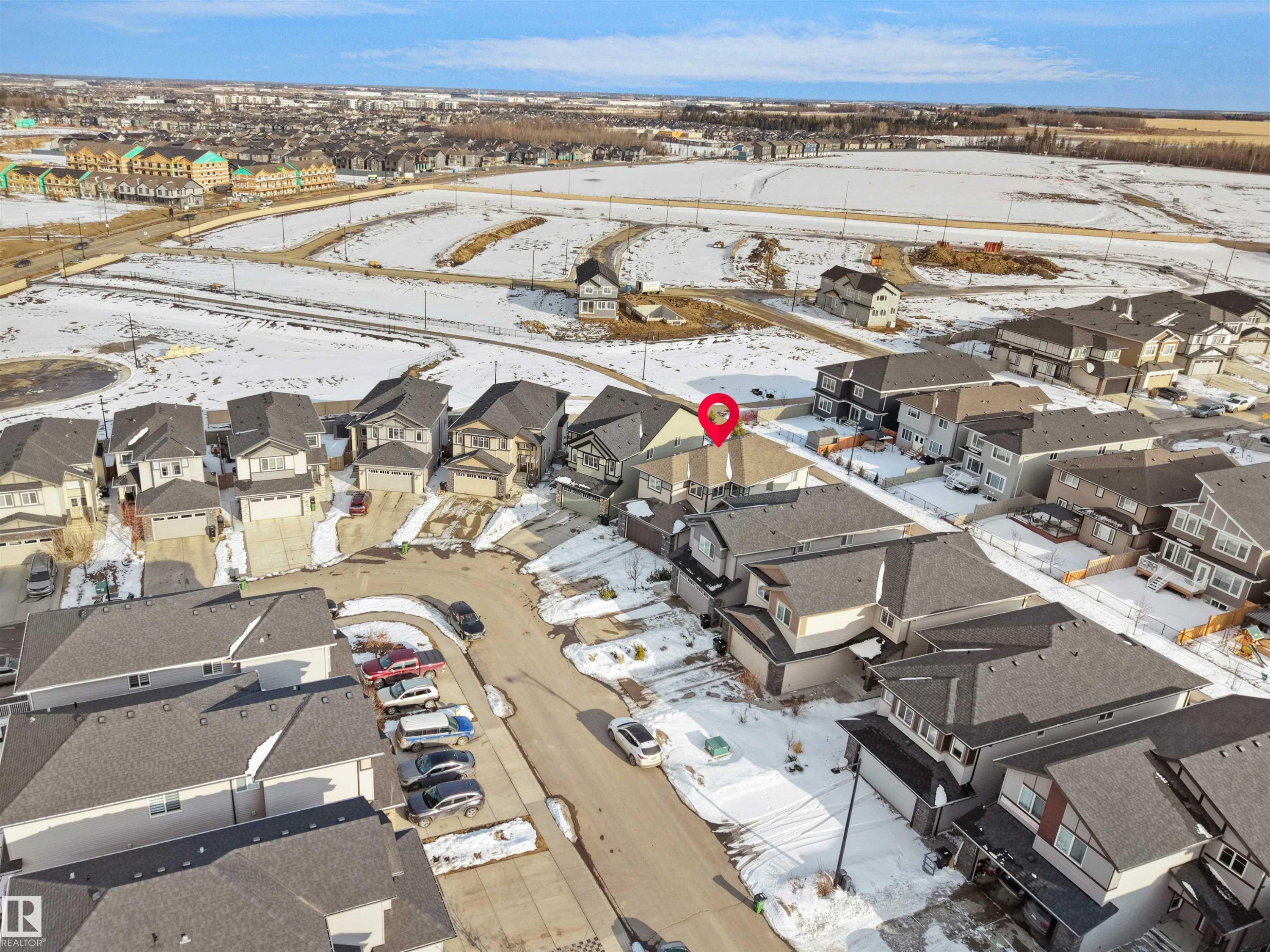 Aerial view showcasing the property within a residential development, featuring a mix of detached homes and townhomes, and proximity to undeveloped land - 4231 Charles Close, Edmonton, AB - Outdoor With View