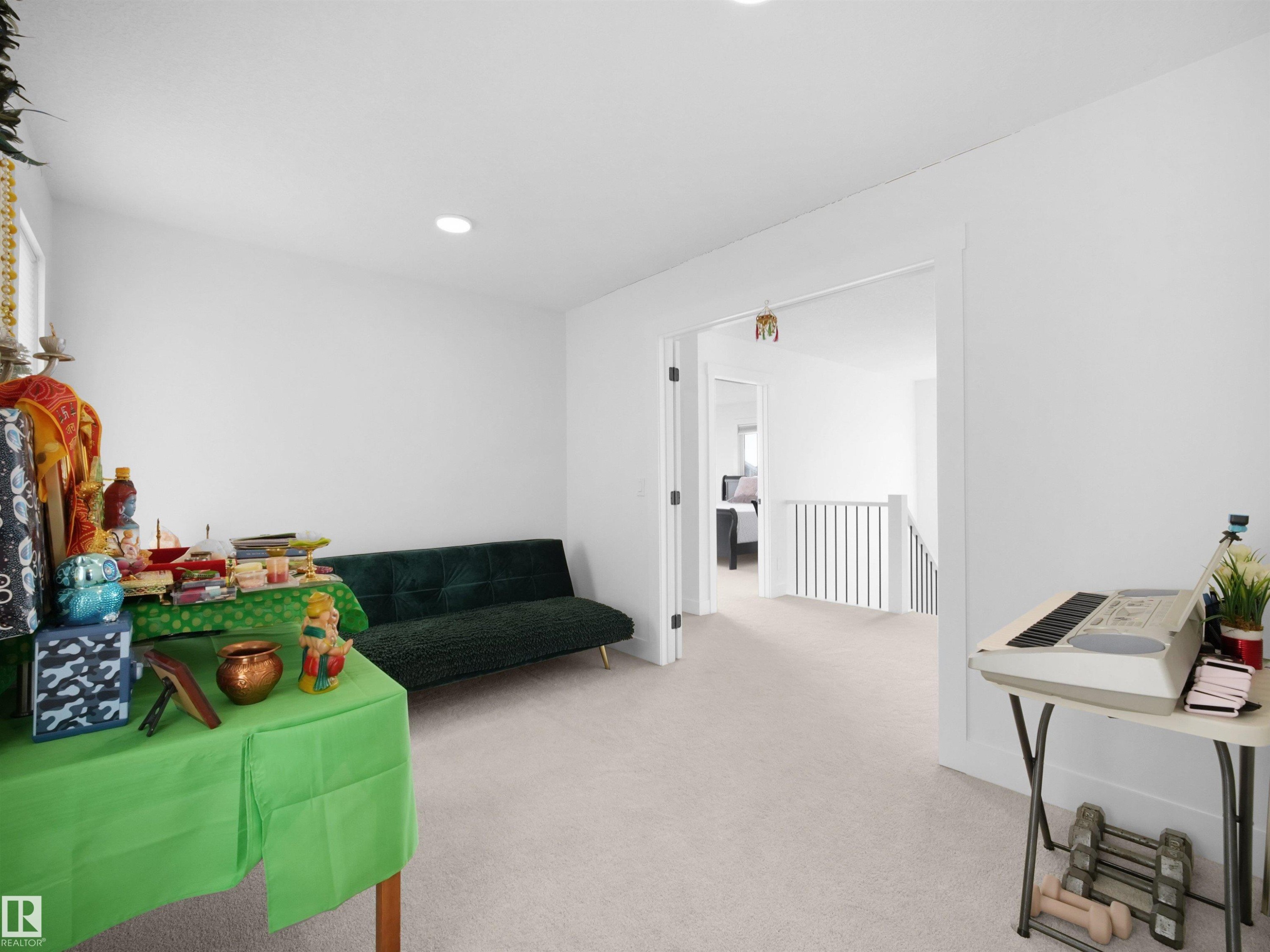 Bright room with light-colored carpeting, recessed lighting, and a wide entryway - 4231 Charles Close, Edmonton, AB - Indoor Photo Showing Other Room