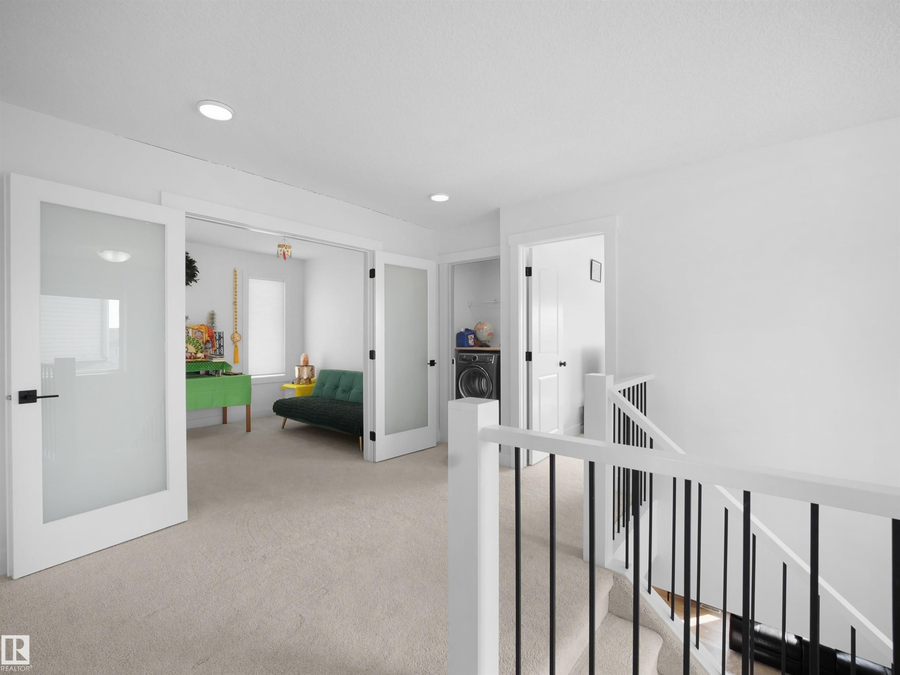 Bright open area with light-colored carpeting, white walls, and recessed lighting - 4231 Charles Close, Edmonton, AB - Indoor Photo Showing Other Room